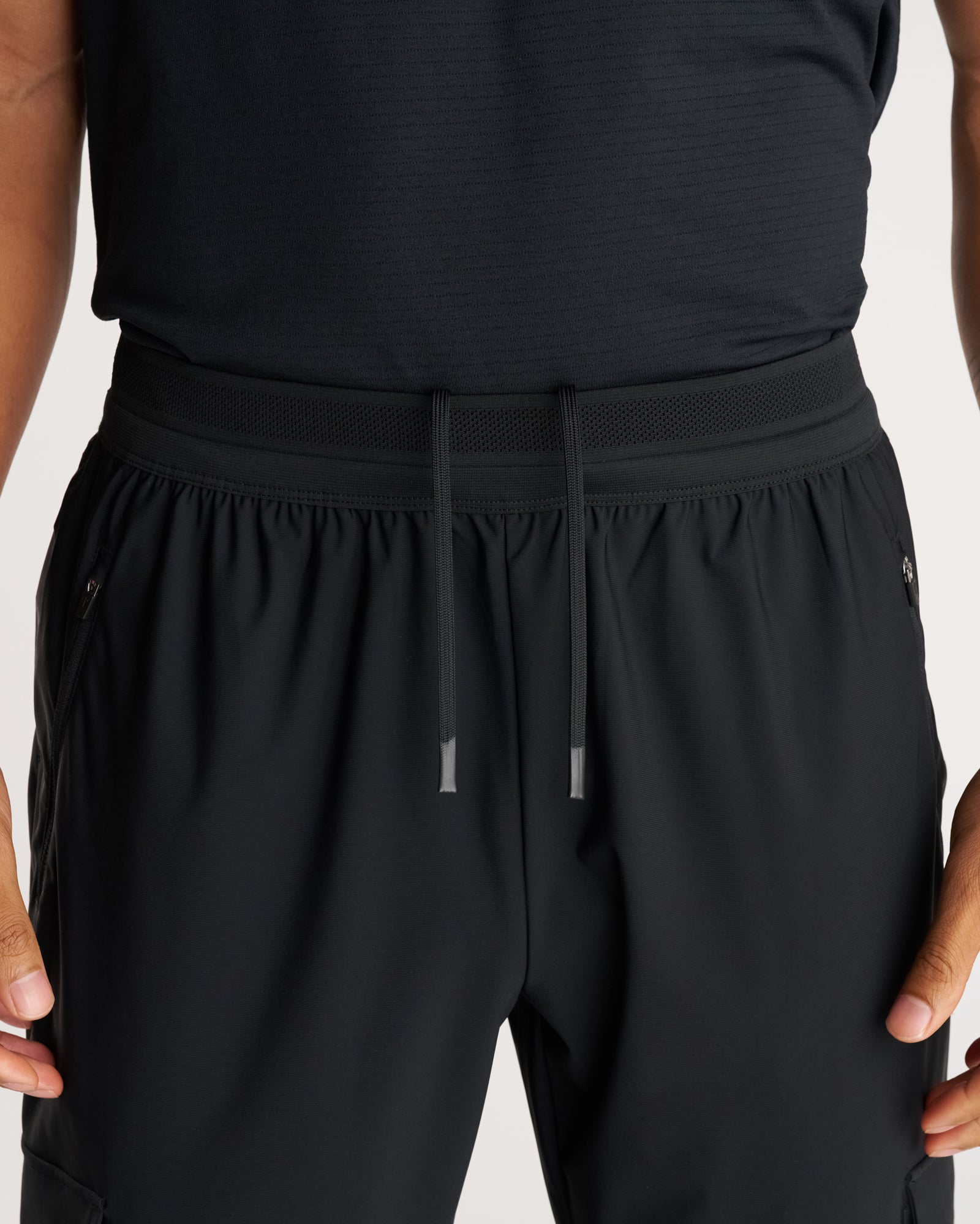 Close-up of Vapor-Lite Cargo Jogger in black showing elastic waistband with mesh panel and drawstring detail.