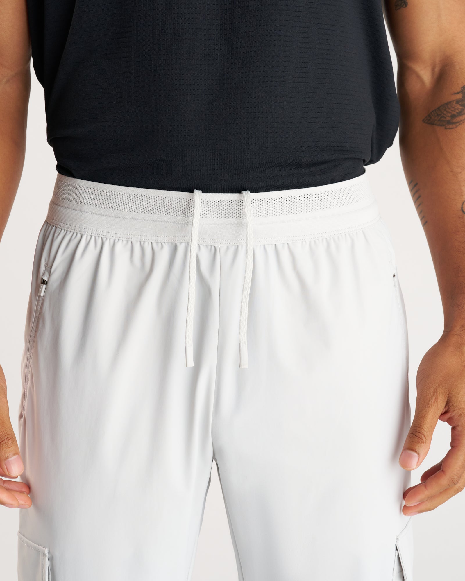 Close-up front view of the Vapor-Lite Cargo Jogger in Stone showing elastic waistband with mesh panel and drawstring.