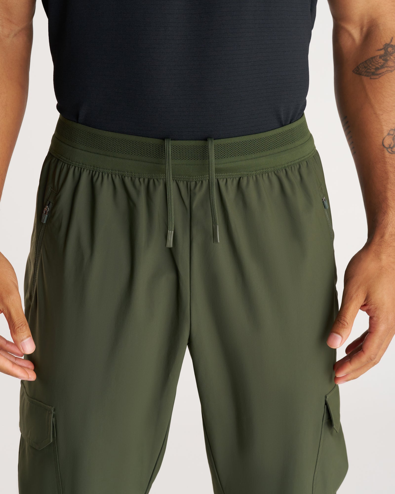 Close-up front view of Vapor-Lite Cargo Jogger in Dark Pine showing mesh waistband and zip pockets.