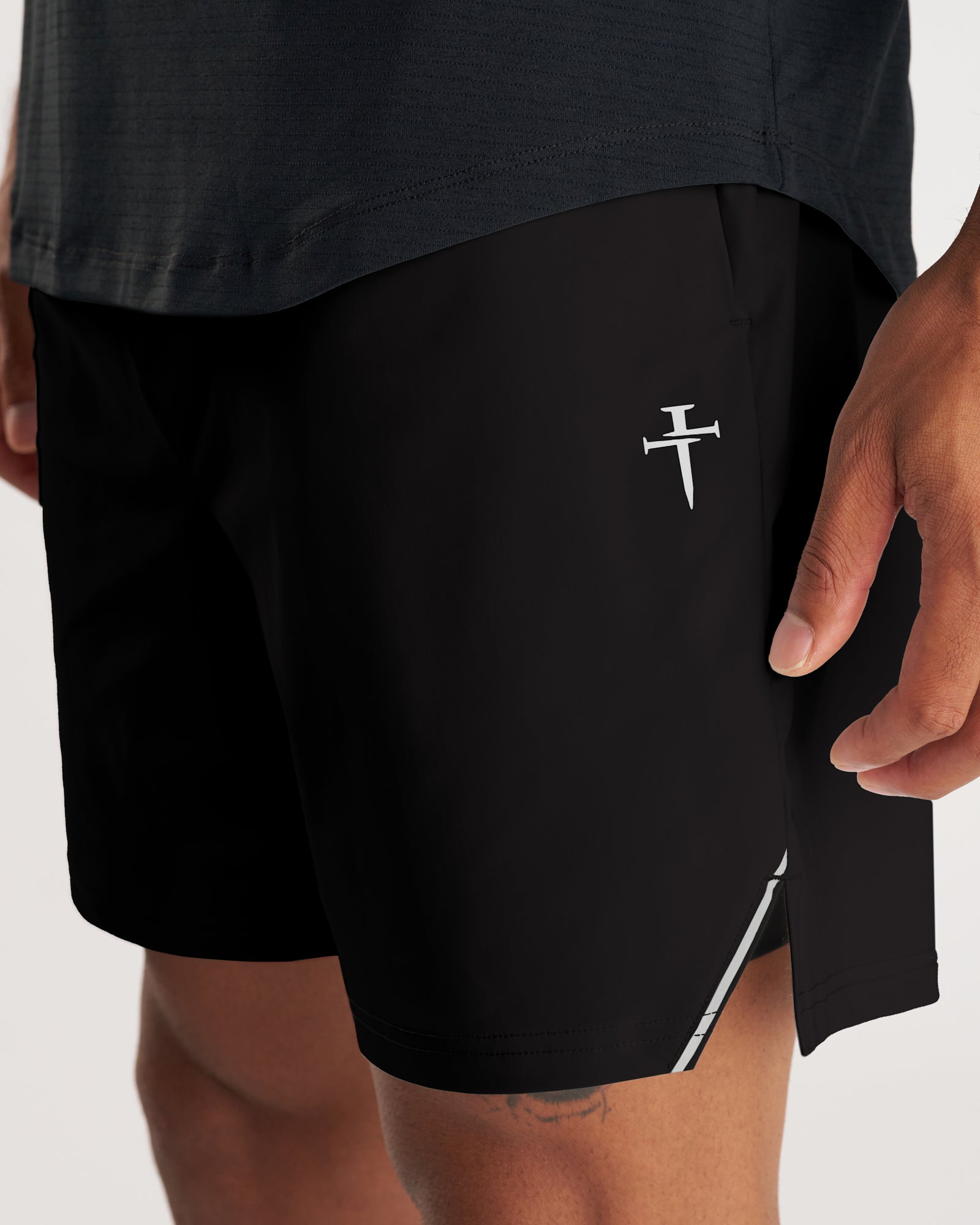Close-up side view of black Vapor-Lite Liner Short Cross showing logo, side vent, and reflective stripe detail.