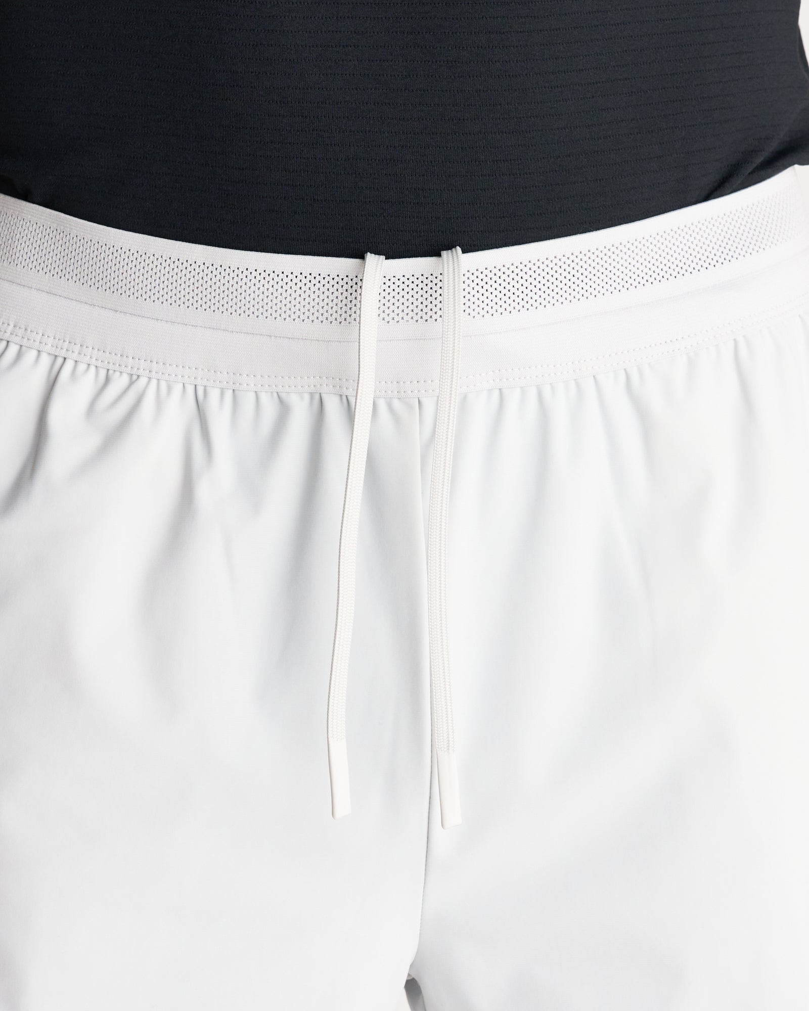 Close-up of Vapor-Lite Liner Short Cross in Stone showing perforated waistband and white drawstring detail.
