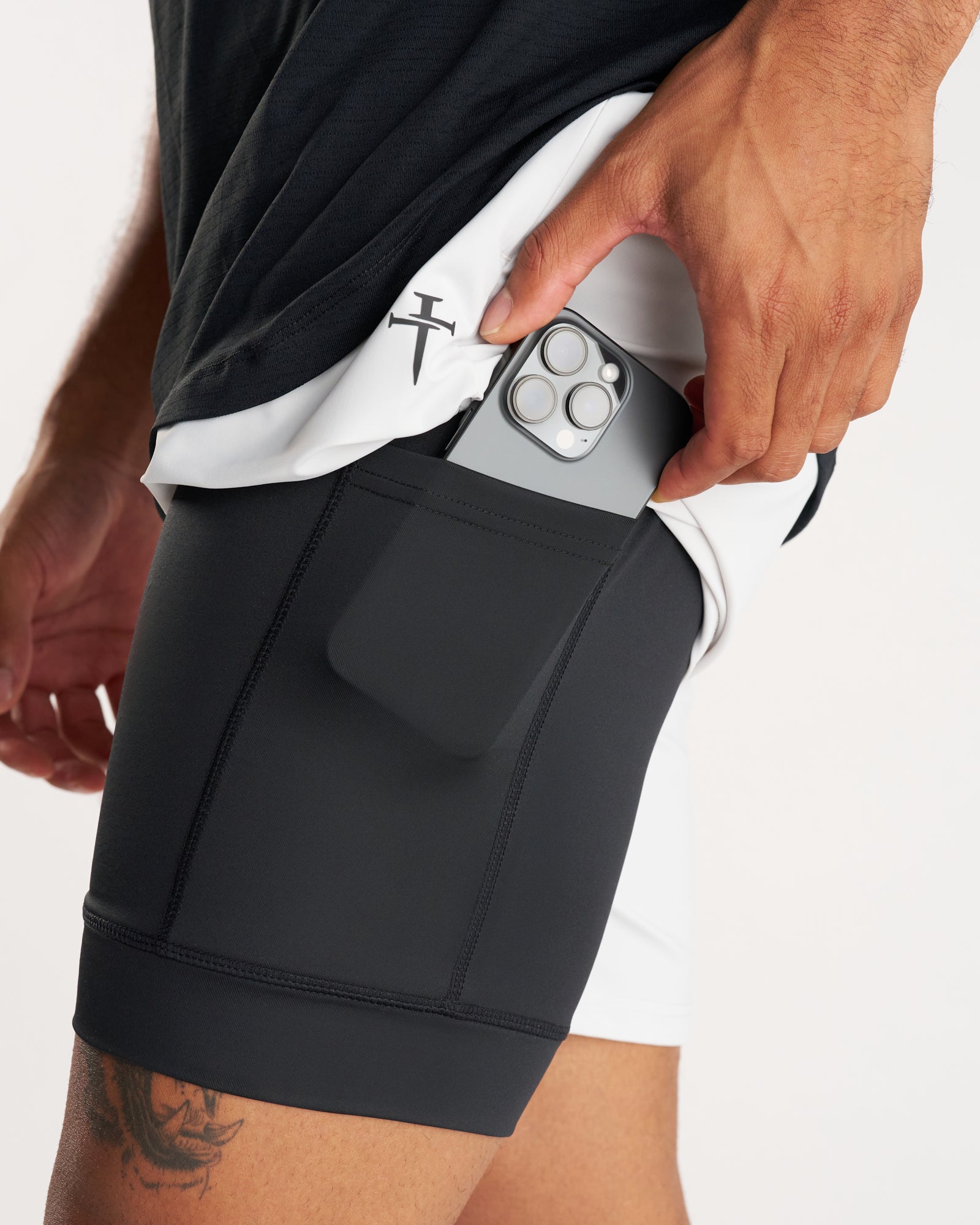 Close-up side view of Vapor-Lite Liner Short Stone showing phone being placed into black compression liner pocket.