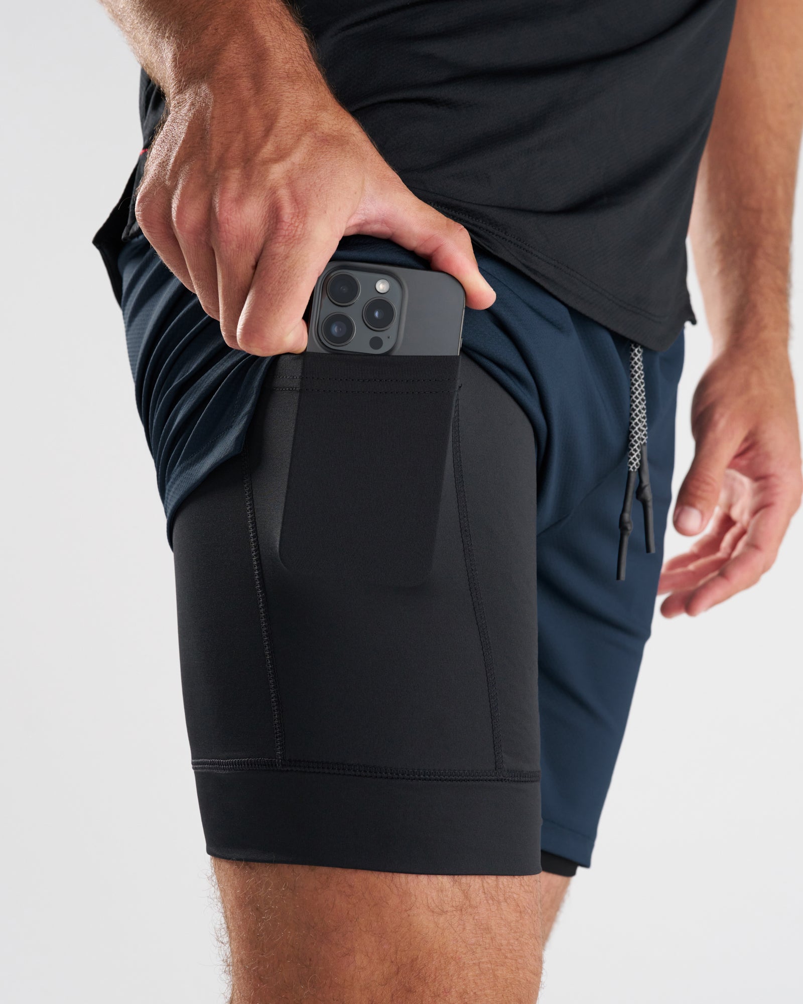 Close-up side view of Pro-Tech 2.0 Liner Short in Midnight Navy showing phone being inserted into inner liner pocket.