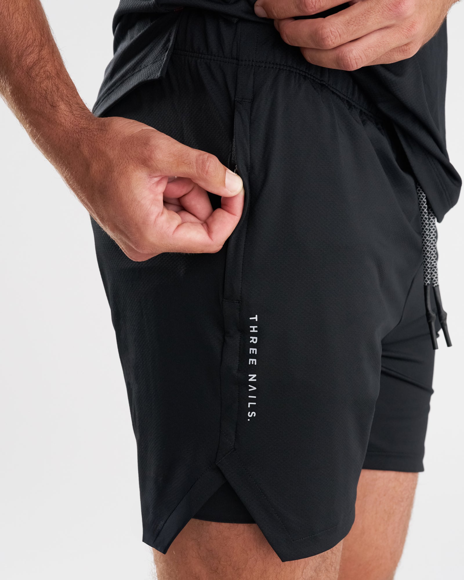 Close-up side view of Pro-Tech 2.0 Liner Short in Black showing zippered pocket detail with model's hand.