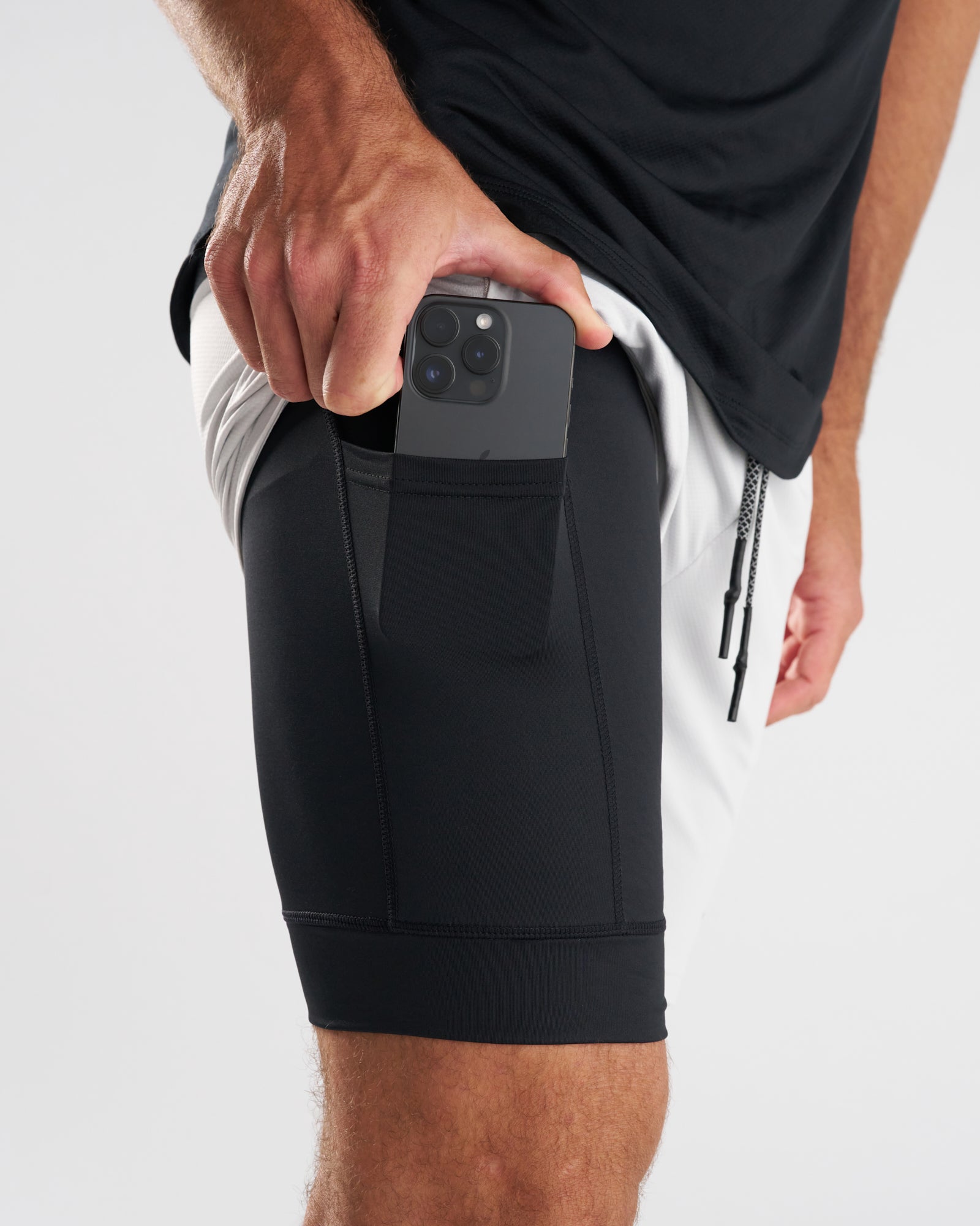 Close-up side view of Pro-Tech 2.0 Liner Short in Stone showing black compression liner pocket with phone being inserted.