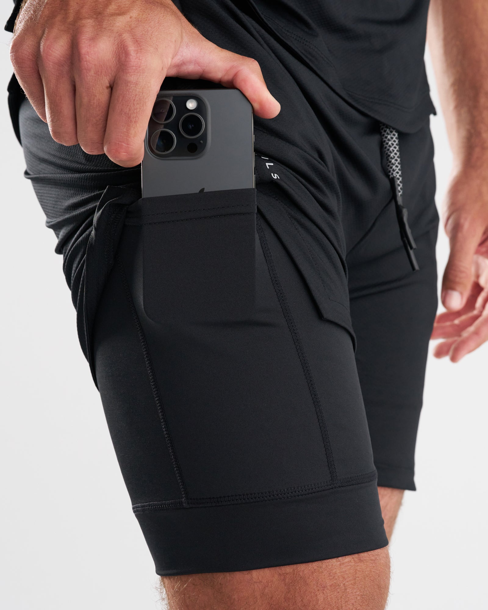 Close-up of Black Pro-Tech 2.0 Liner Short side pocket with a phone being inserted.