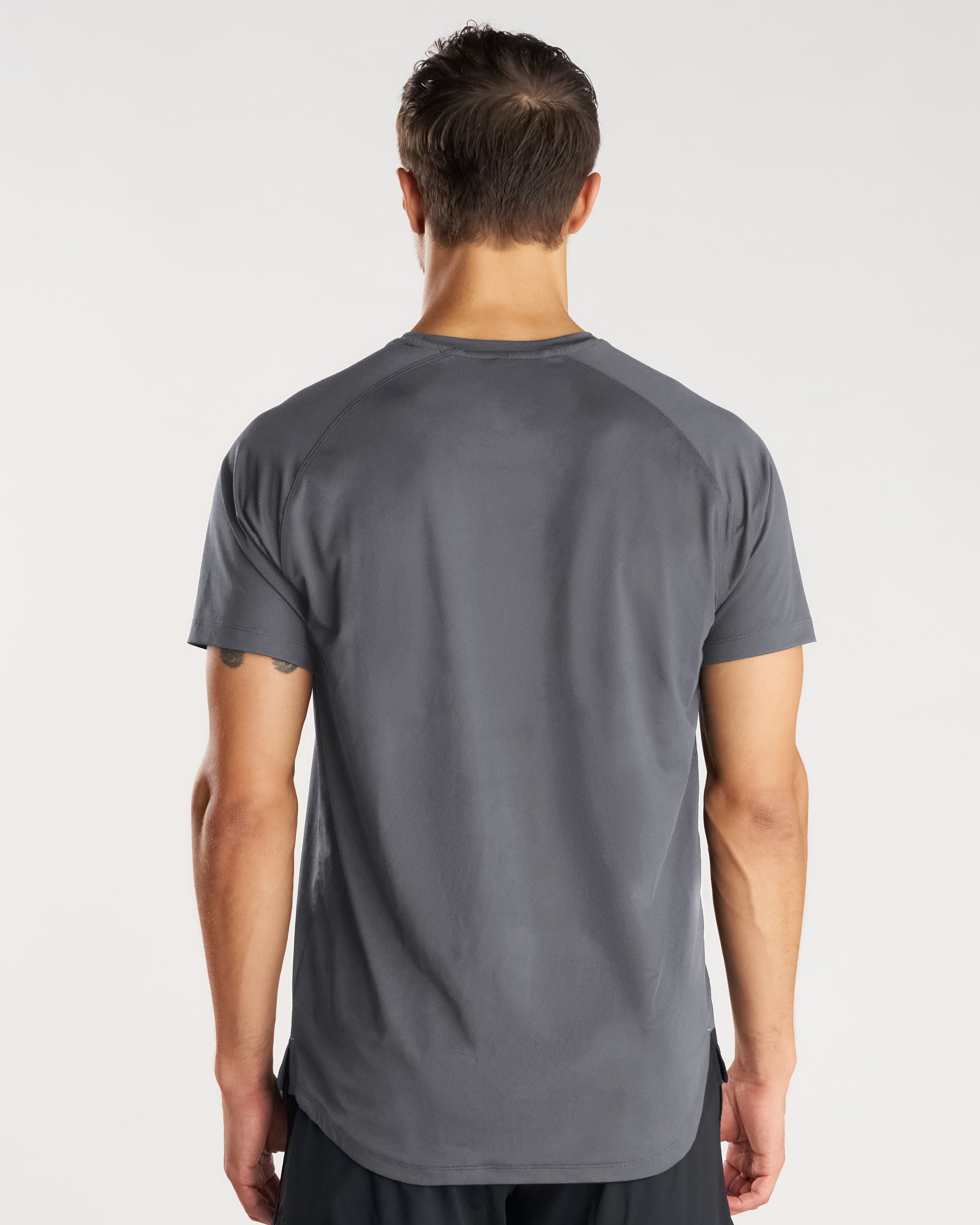 Back view of the Pro-Tech Tee Cross in Space Grey, showing raglan seams and curved hem.