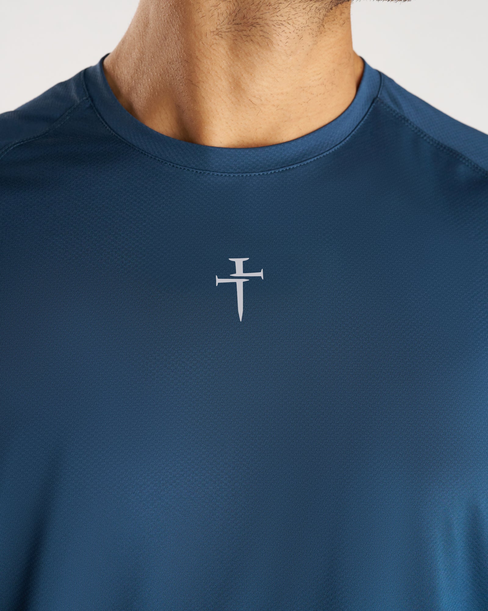 Close-up front view of Pro-Tech Tee Cross in Midnight Navy showing the silver nail cross logo at center chest.