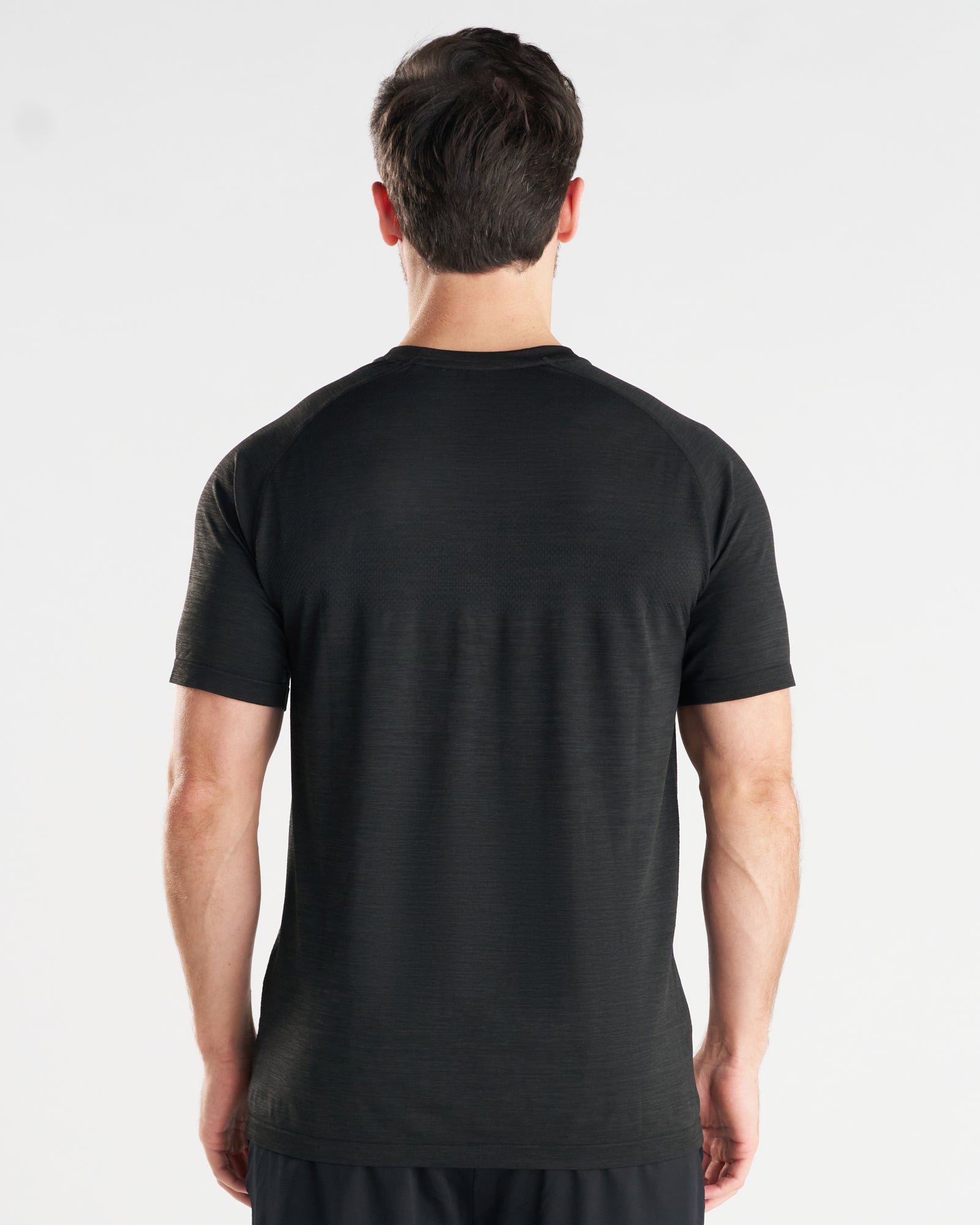 Black Marl Seamless Tee on model, back view showing raglan seams and mesh ventilation panels