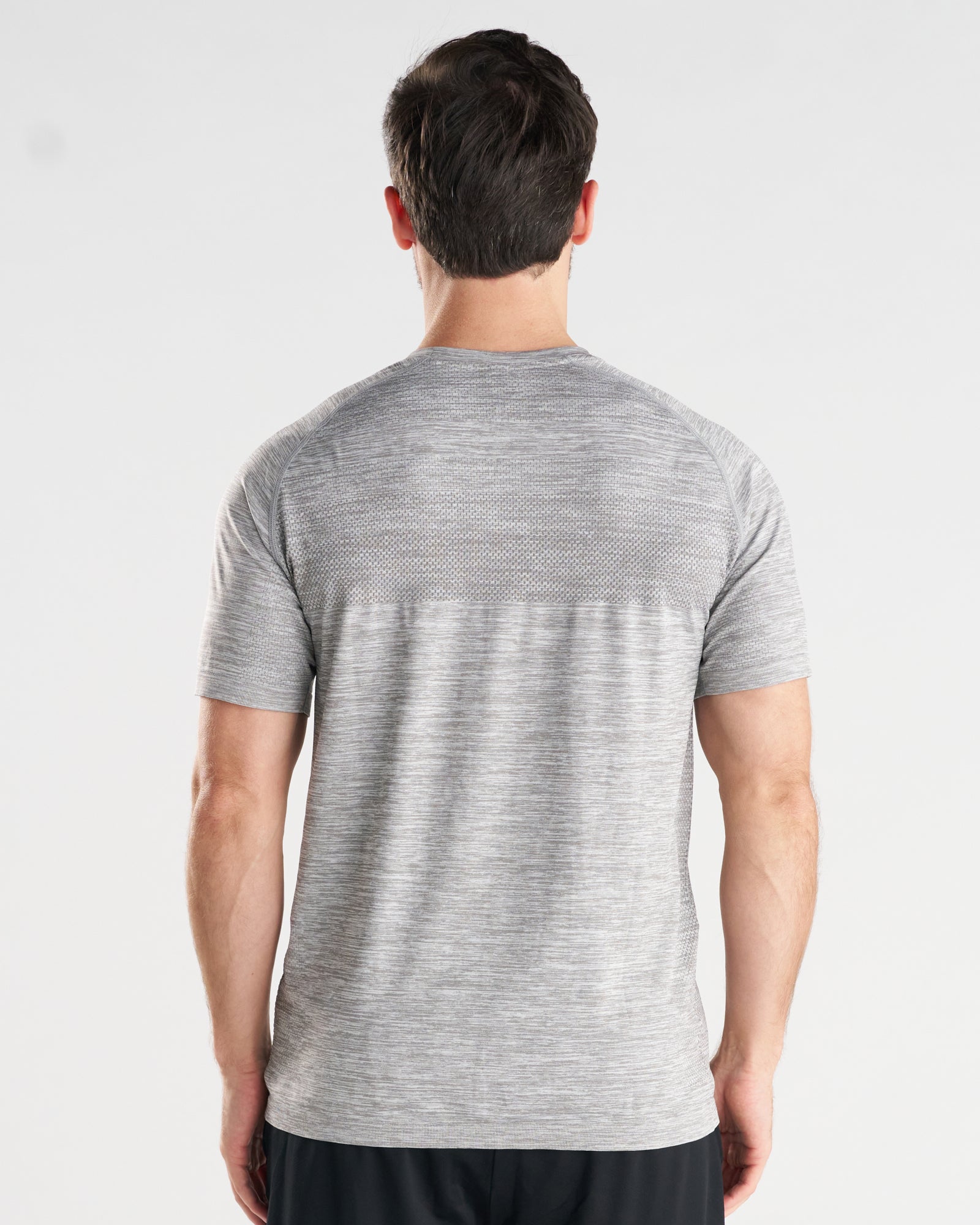 Back view of model wearing the Seamless Tee in Grey Marl, showing textured mesh panel across upper back.