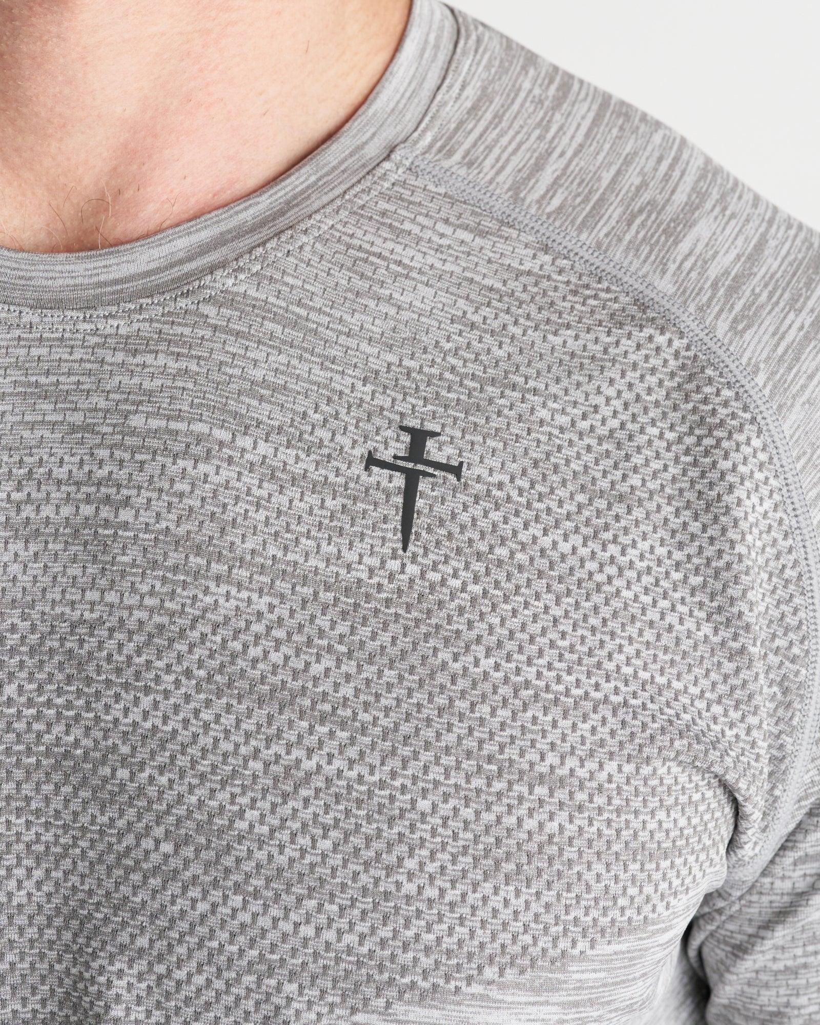 Close-up chest detail of the Seamless Grey Marl Tee showing textured fabric and Three Nails logo.