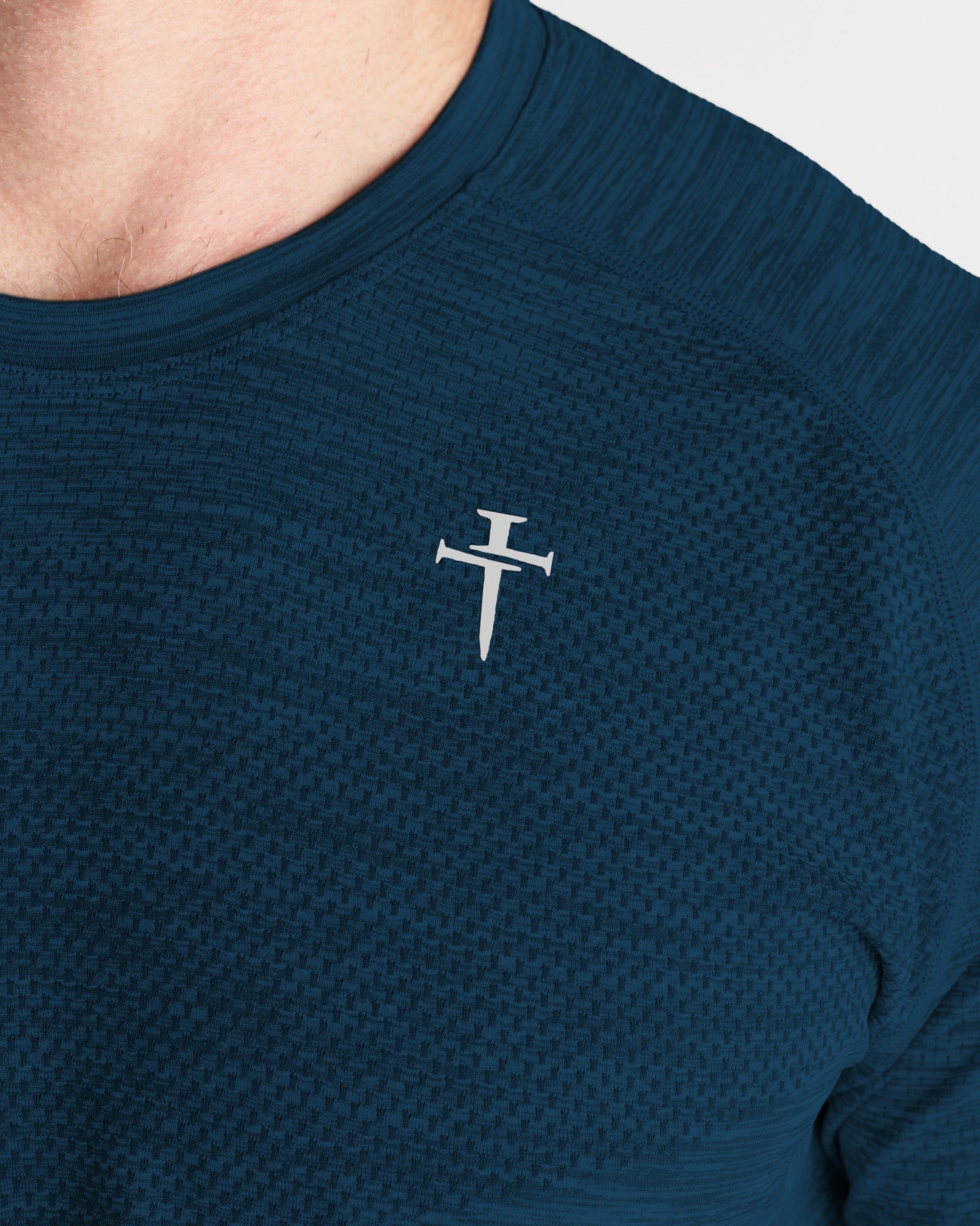 Close-up of Seamless Tee in Midnight Navy showing textured fabric and Three Nails logo on chest.