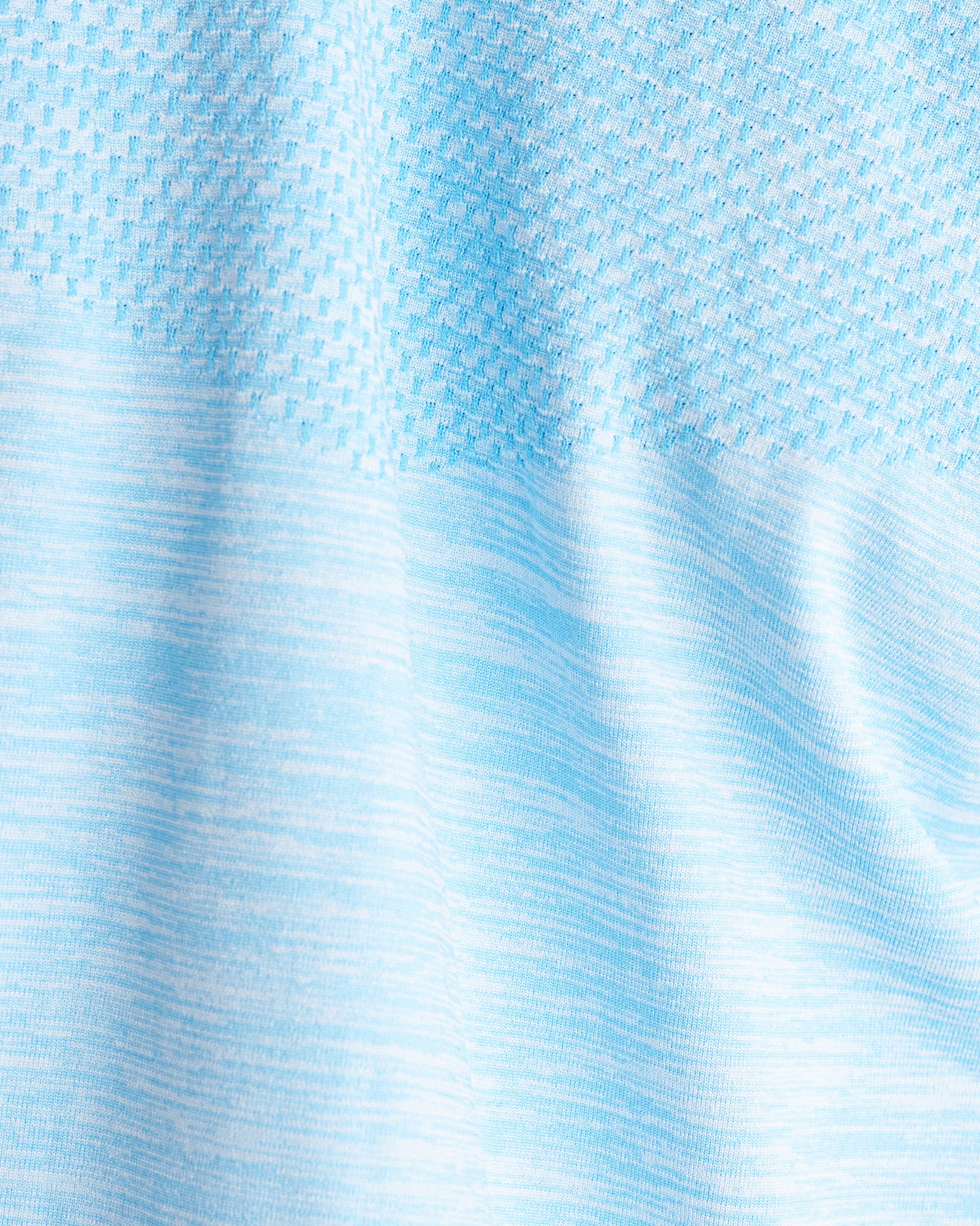 Close-up detail of the Seamless Tee in Sky Blue showing mixed knit textures with blue and white heathered fabric.
