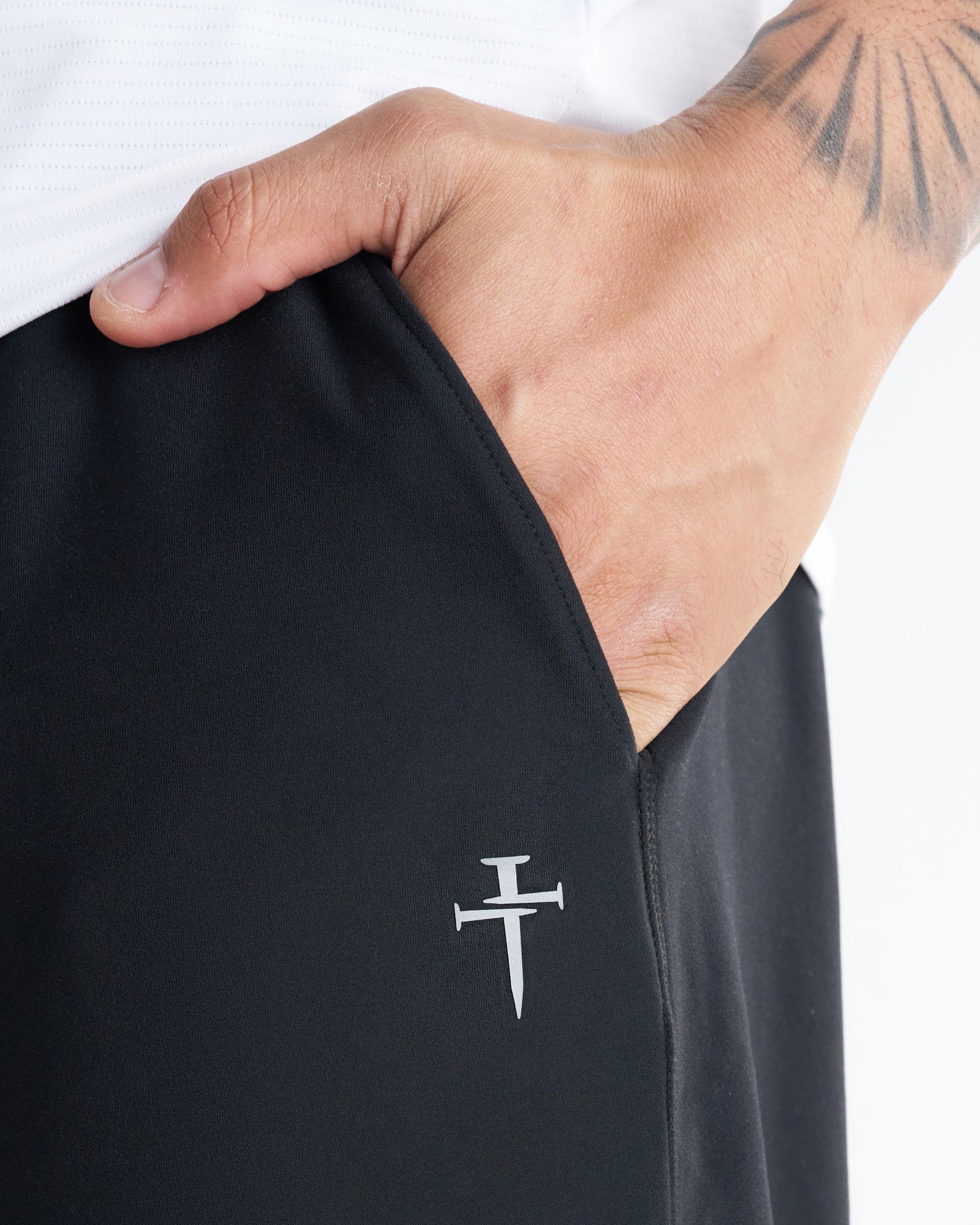Close-up of black Haven Performance Jogger showing side pocket and small Three Nails logo on a male model.