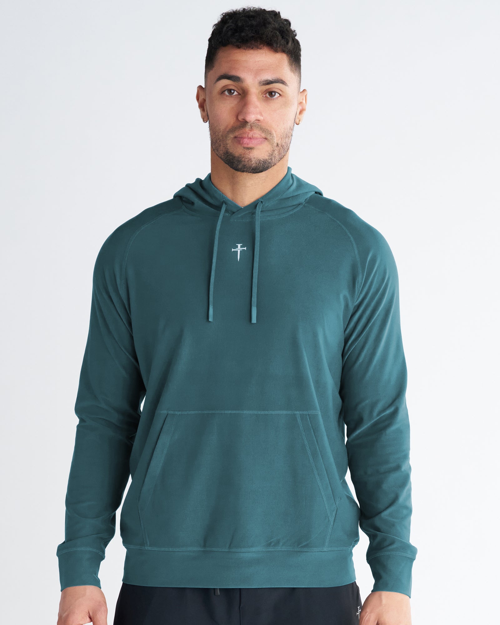 Haven Performance Hoodie in teal on a male model, front view, with a small cross logo at the chest.