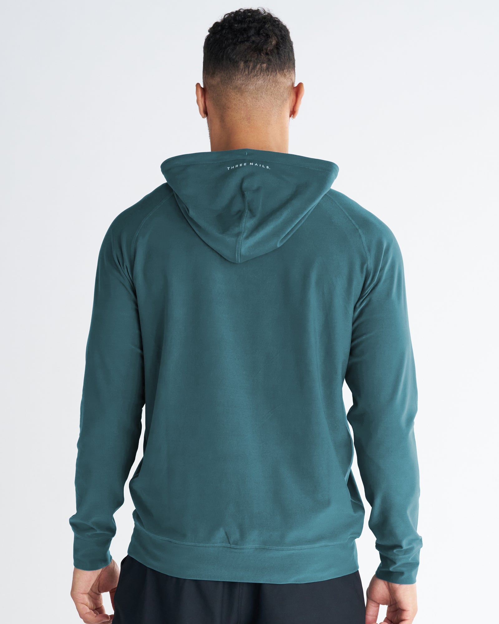 Haven Performance Hoodie in teal shown from the back on a male model standing upright.