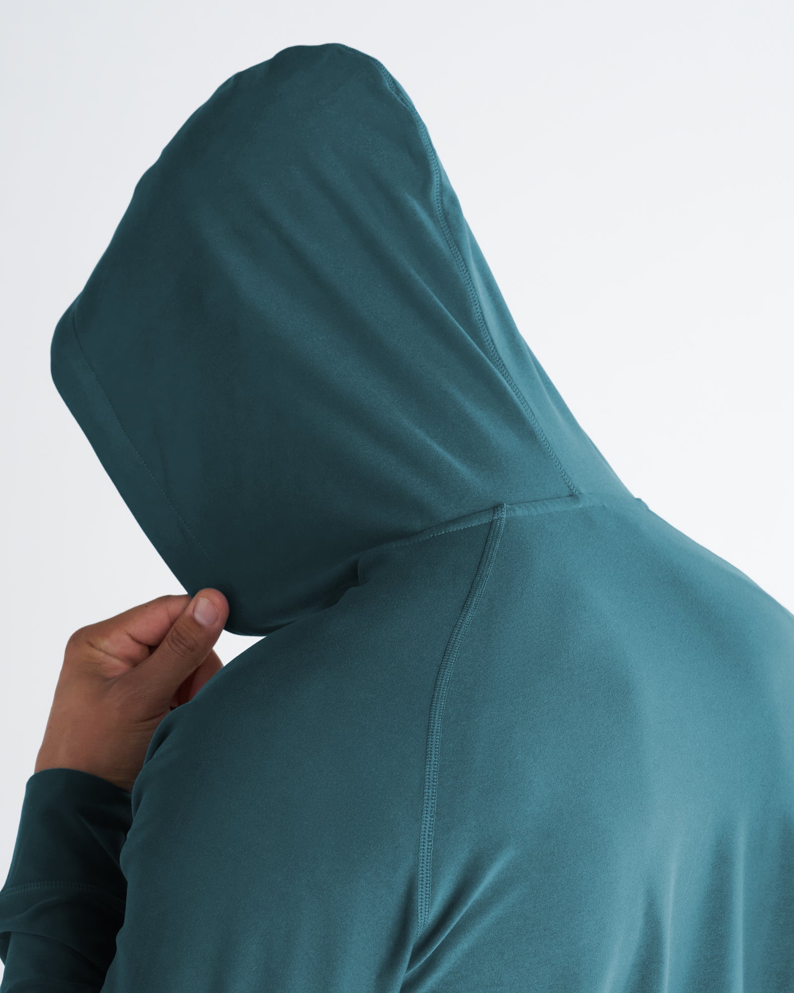 Close-up back view of Haven Performance Hoodie in teal, showing hood structure and seam detail.