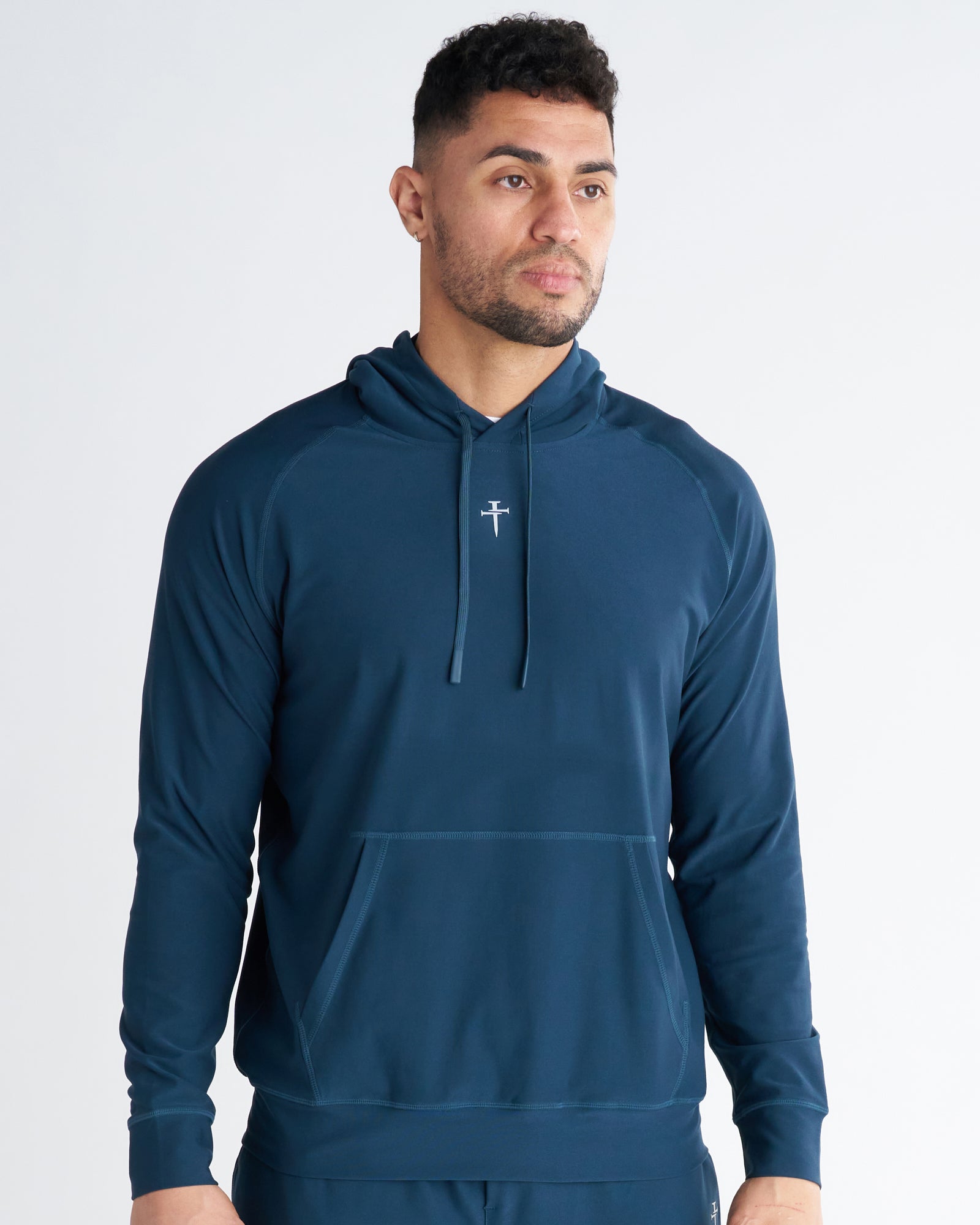 Haven Performance Hoodie in Midnight Navy, front view on male model, featuring kangaroo pocket and center logo.