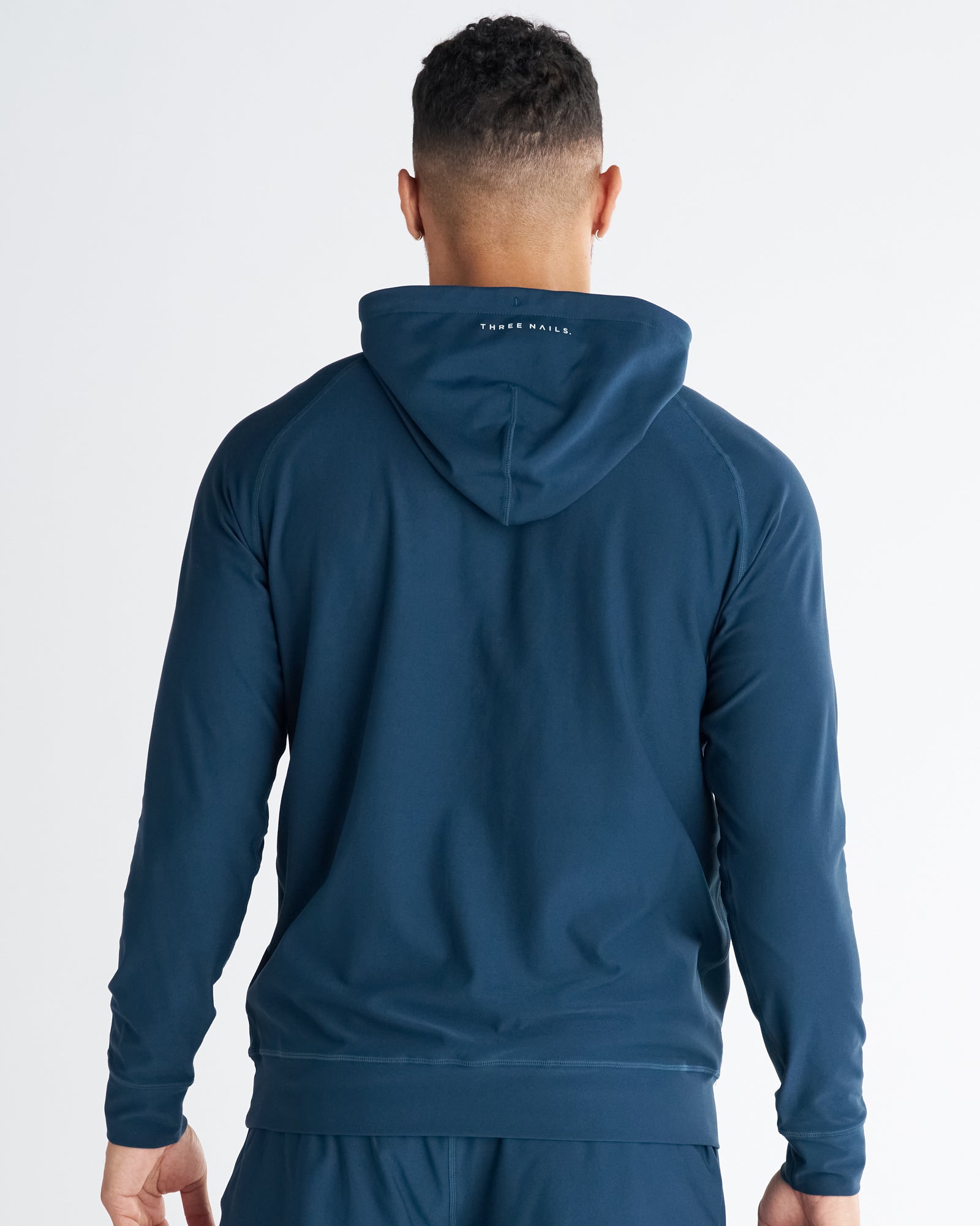 Haven Performance Hoodie in Midnight Navy shown from the back on a male model standing upright.