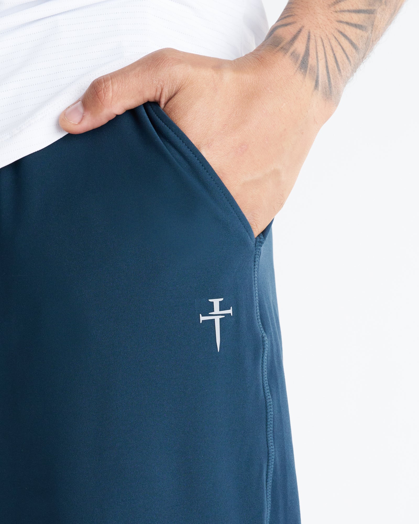 Close-up of Haven Performance Jogger in Midnight Navy showing side pocket and white Three Nails logo detail.
