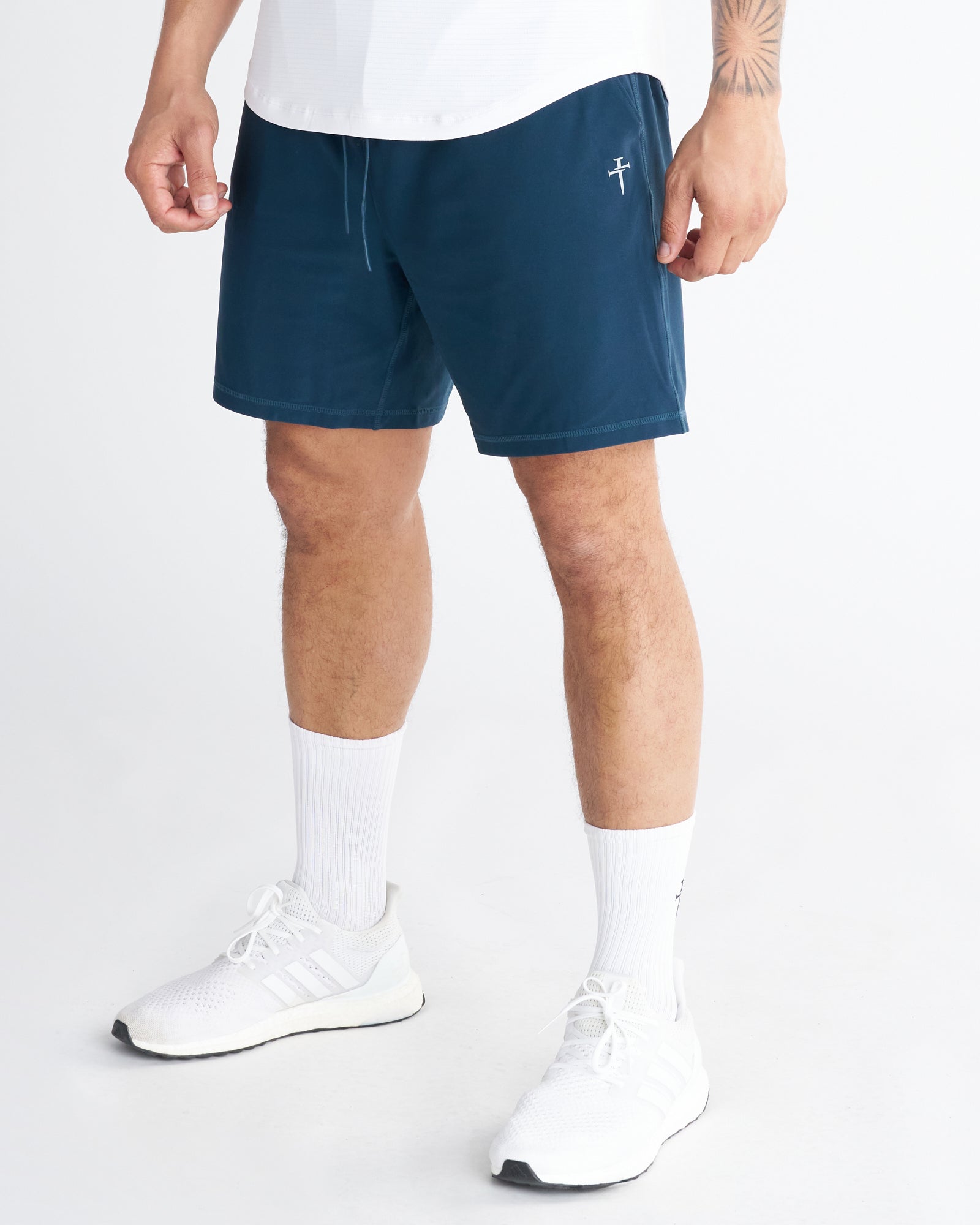 Haven Performance Short in Midnight Navy on a model, side angle view, showing drawstring waist and small logo detail.