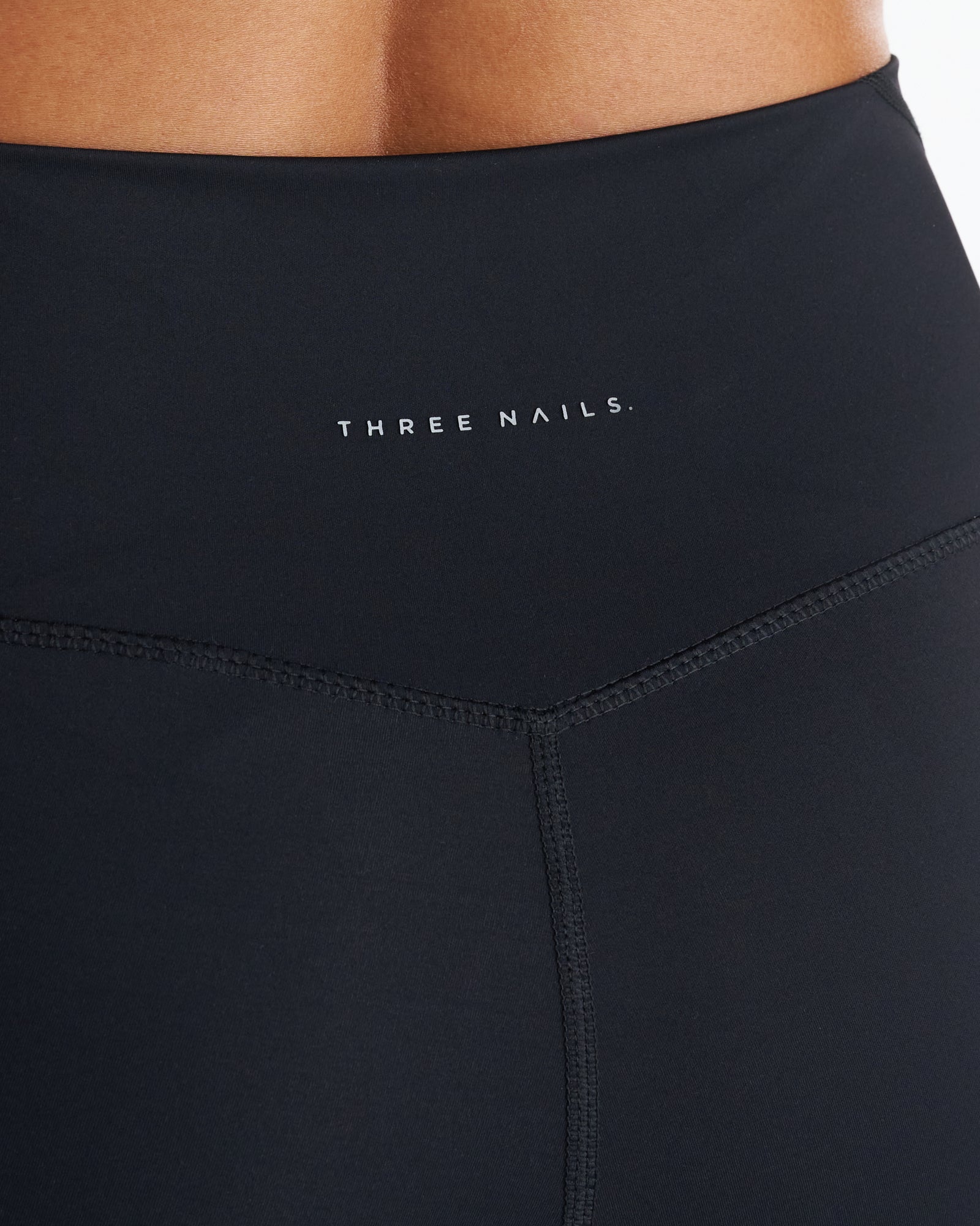 Close-up of the Endura-Train Pocket Legging in black showing the waistband, V-seam detail, and Three Nails logo.