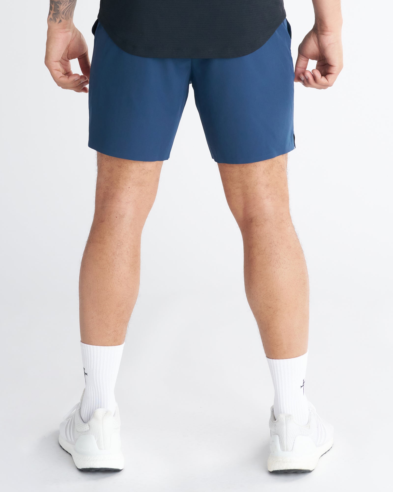 Back view of Pulse Tech Linerless Short in Midnight Navy worn with white sneakers and crew socks.