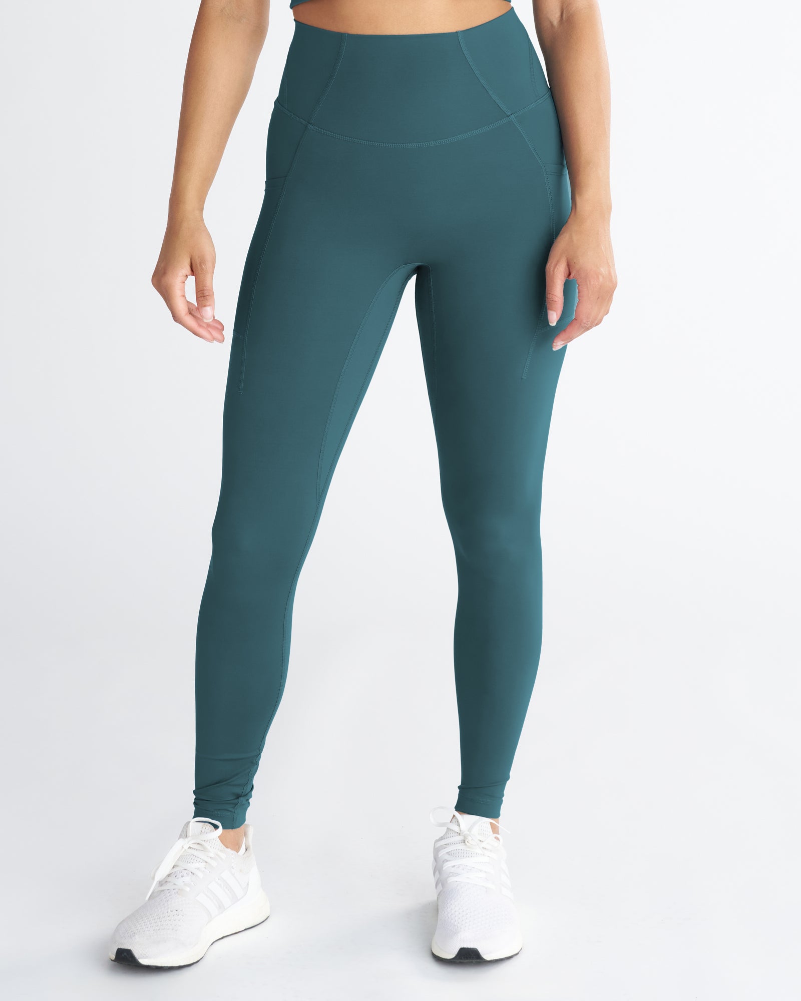 Endura-Train Pocket Legging in Teal, front view on model showing high waistband and side pockets.