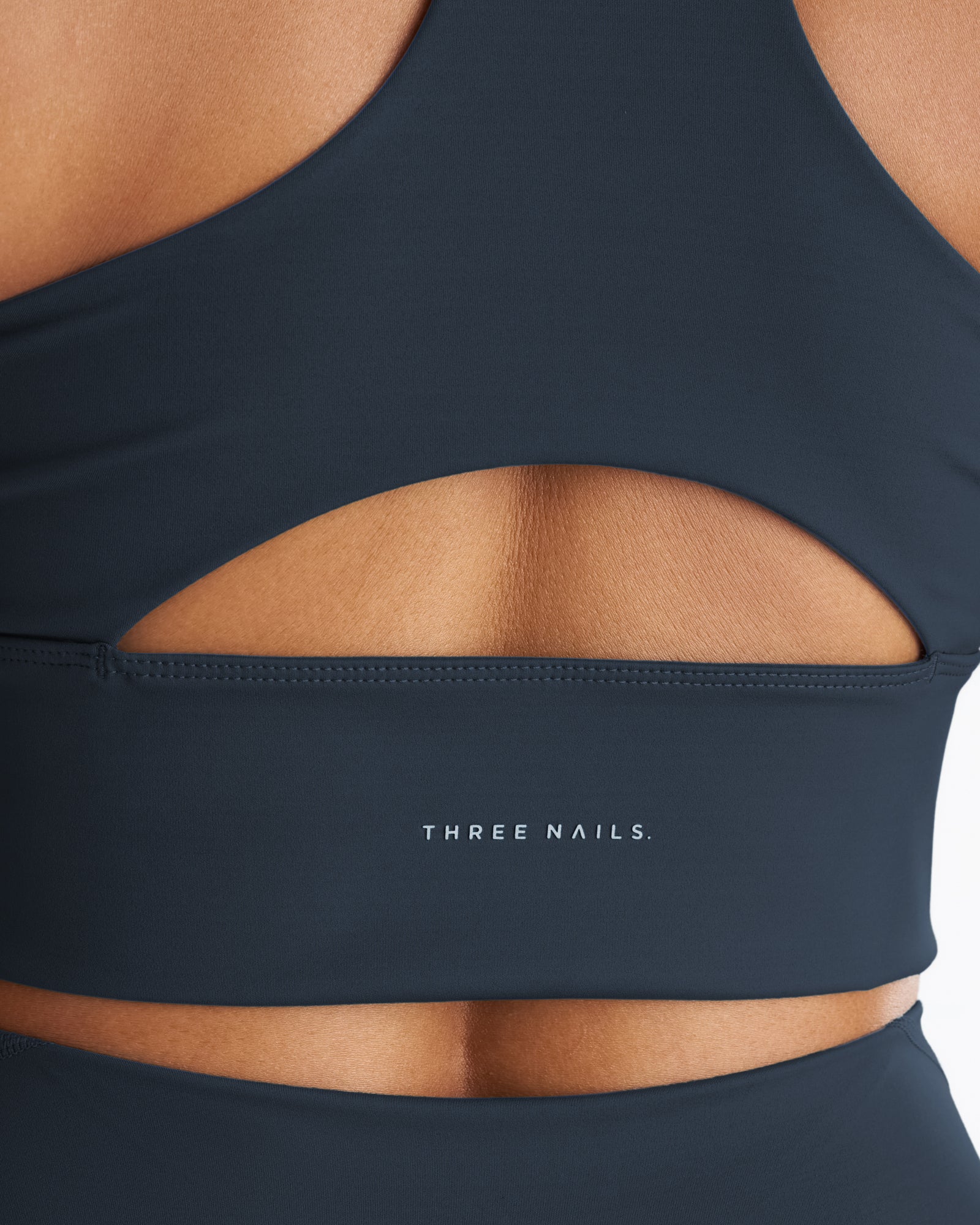 Close-up back detail of the Endura-Train Longline Bra in Midnight Navy showing cutout design and logo band.