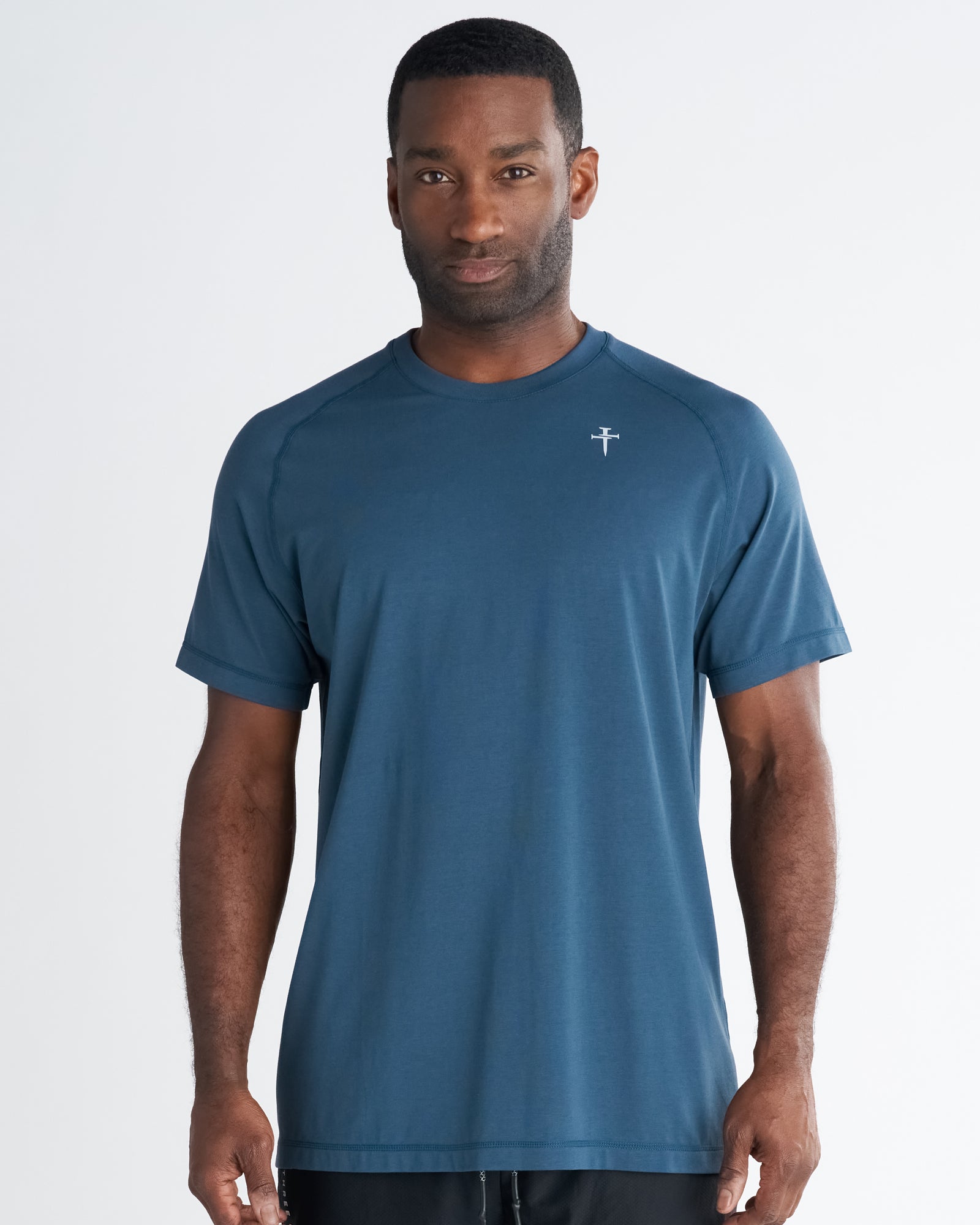 Man wearing Core Tee in Midnight Navy, front view, short sleeve crew neck with small logo on chest.