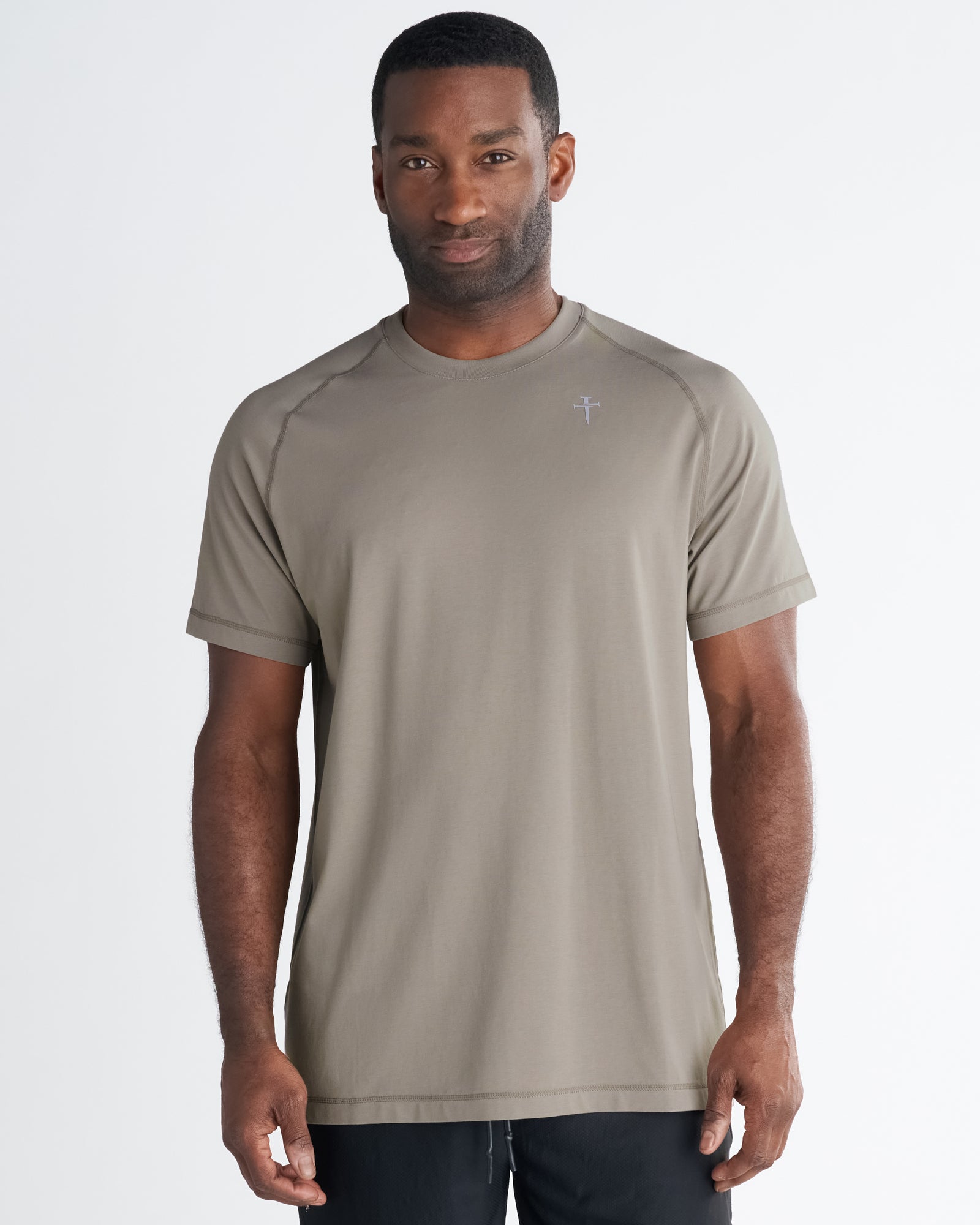 Man wearing Core Tee in Sand, front view, relaxed fit with raglan sleeves and small logo on chest.