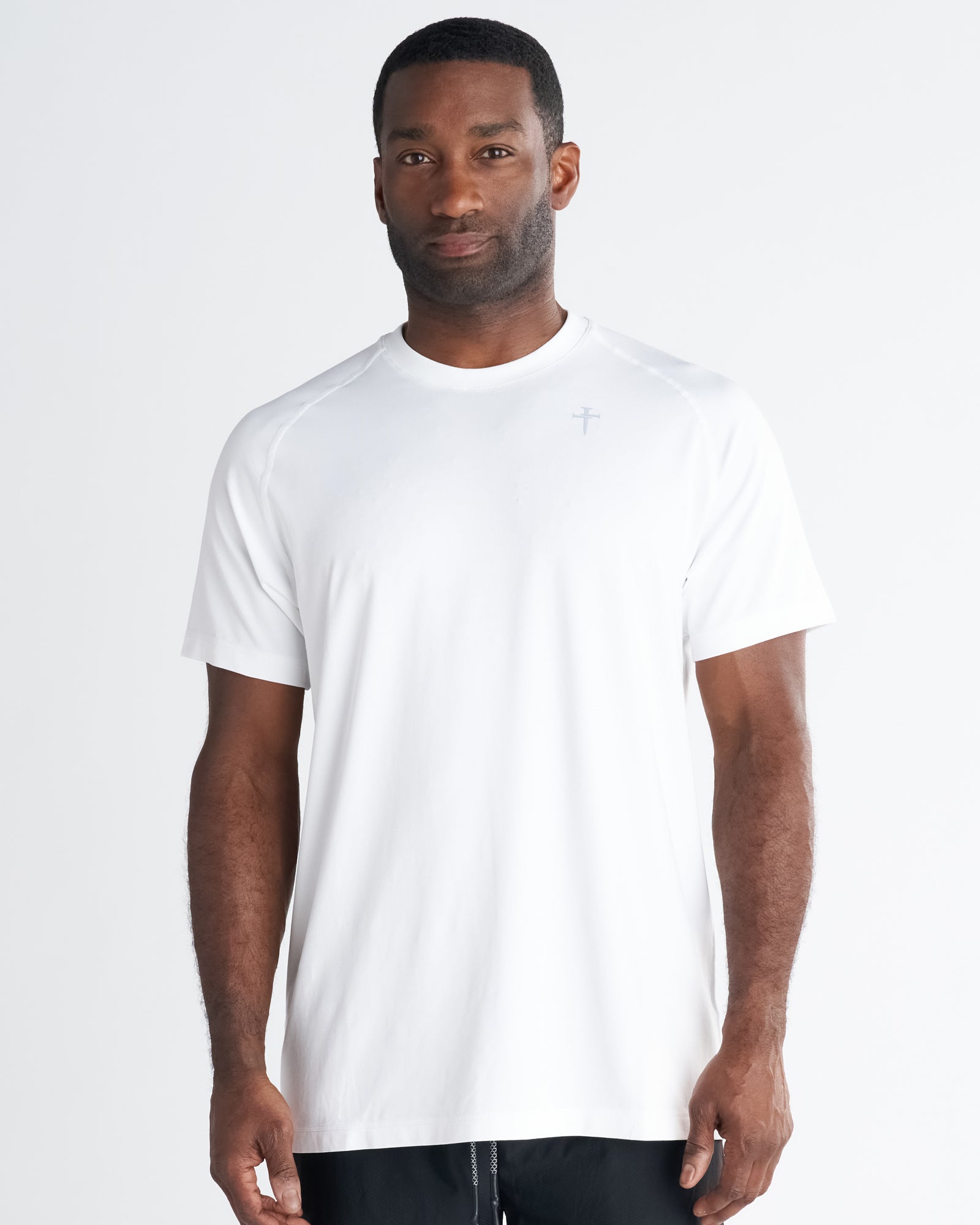 Man wearing the Core Tee in white, front view, with a small logo on the chest and raglan sleeves.