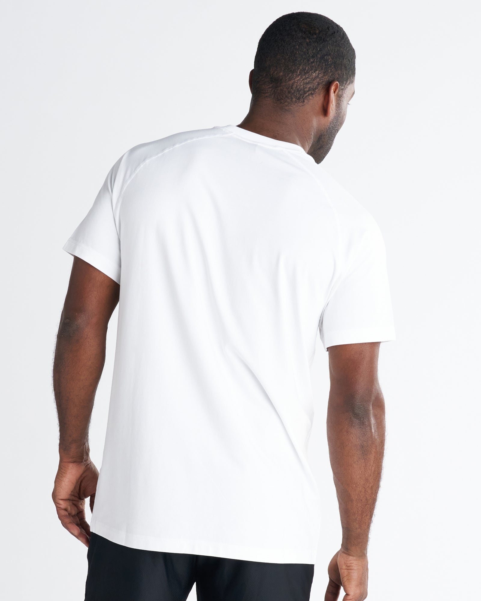 Back view of a man wearing the Core Tee in white, showing a clean relaxed fit with short sleeves.