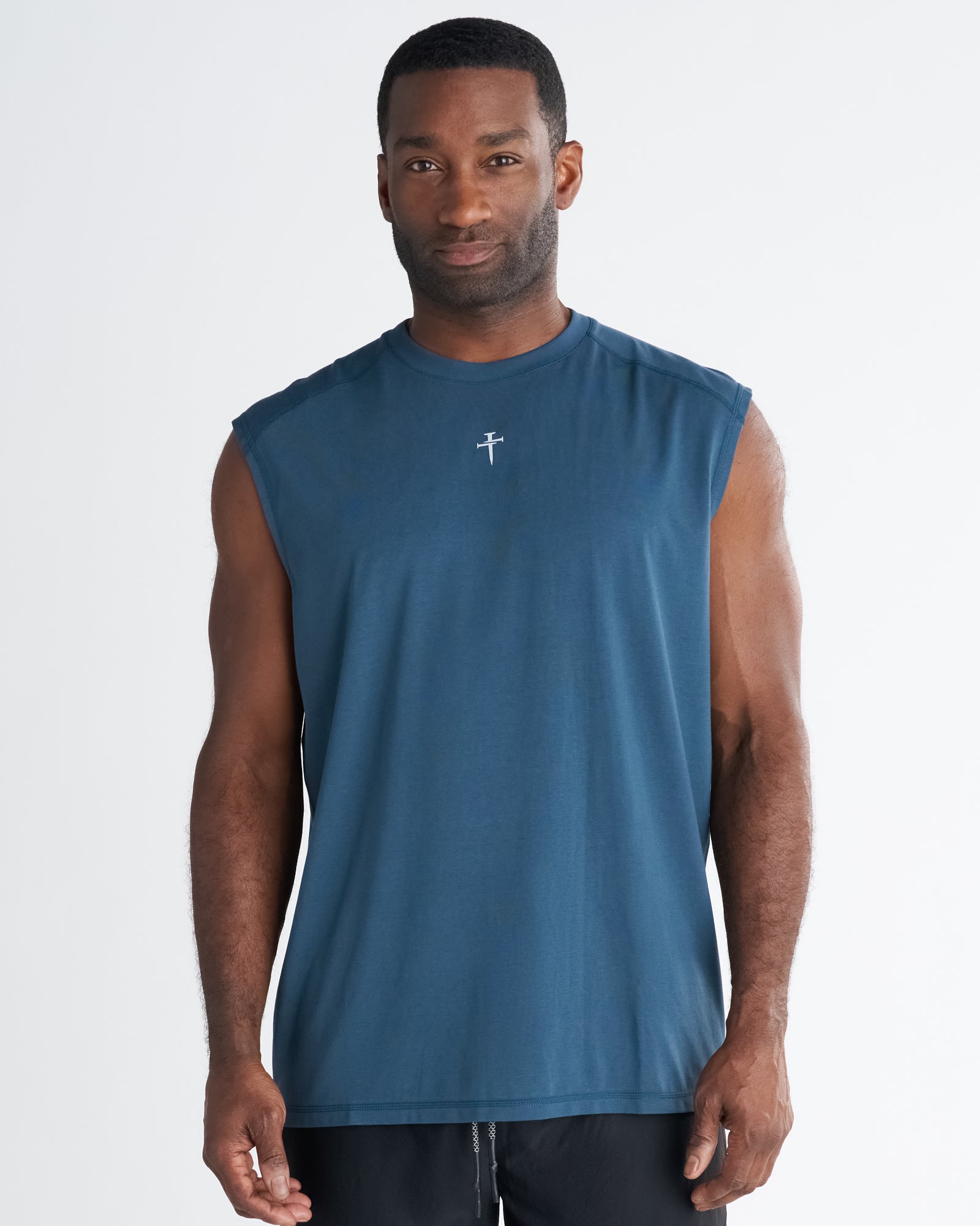 Man wearing Core Raglan Cutoff in Midnight Navy, front view, with small cross logo on chest.