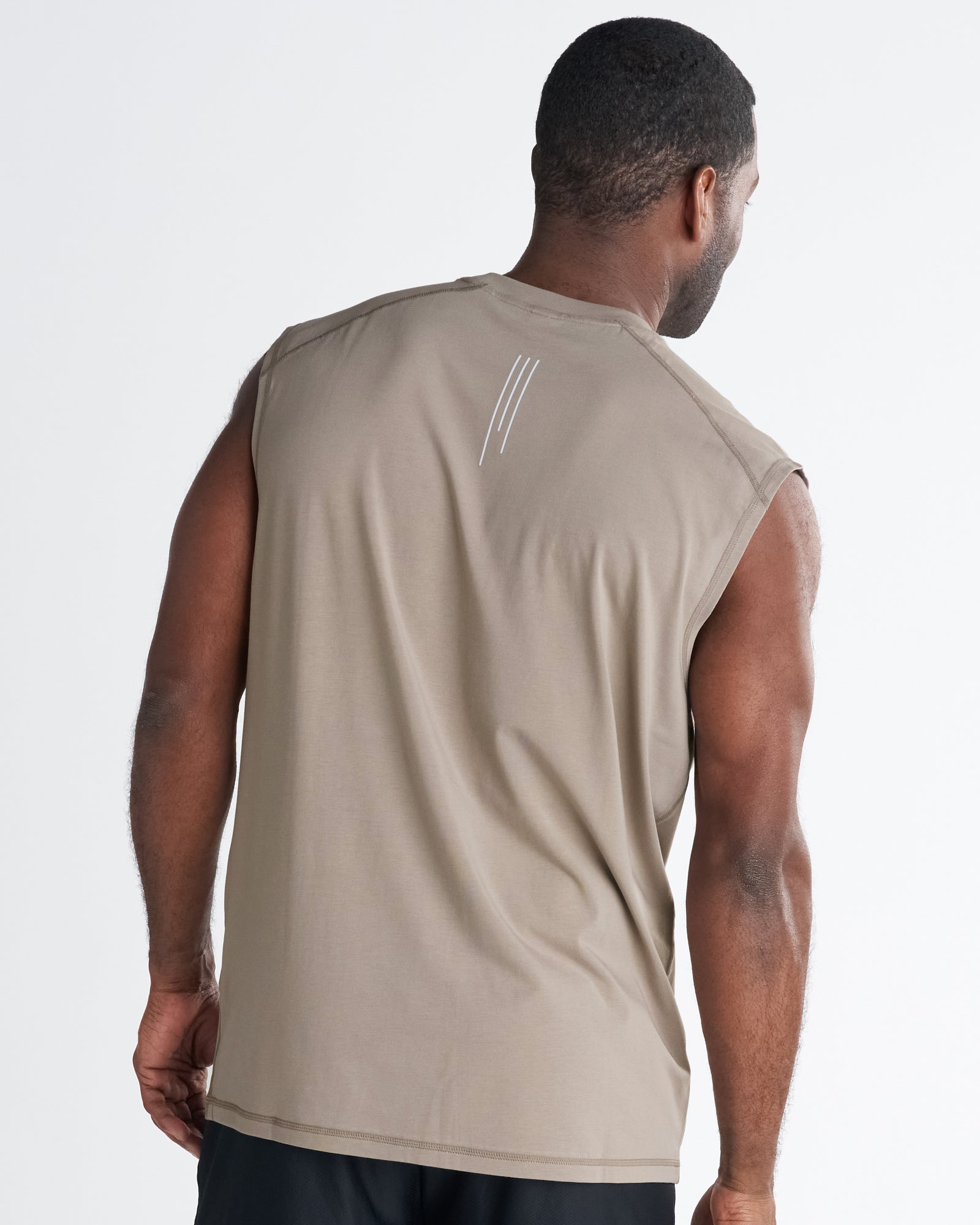 Back view of the Core Raglan Cutoff in Sand, a sleeveless tan top with a small three-line logo at the upper back.