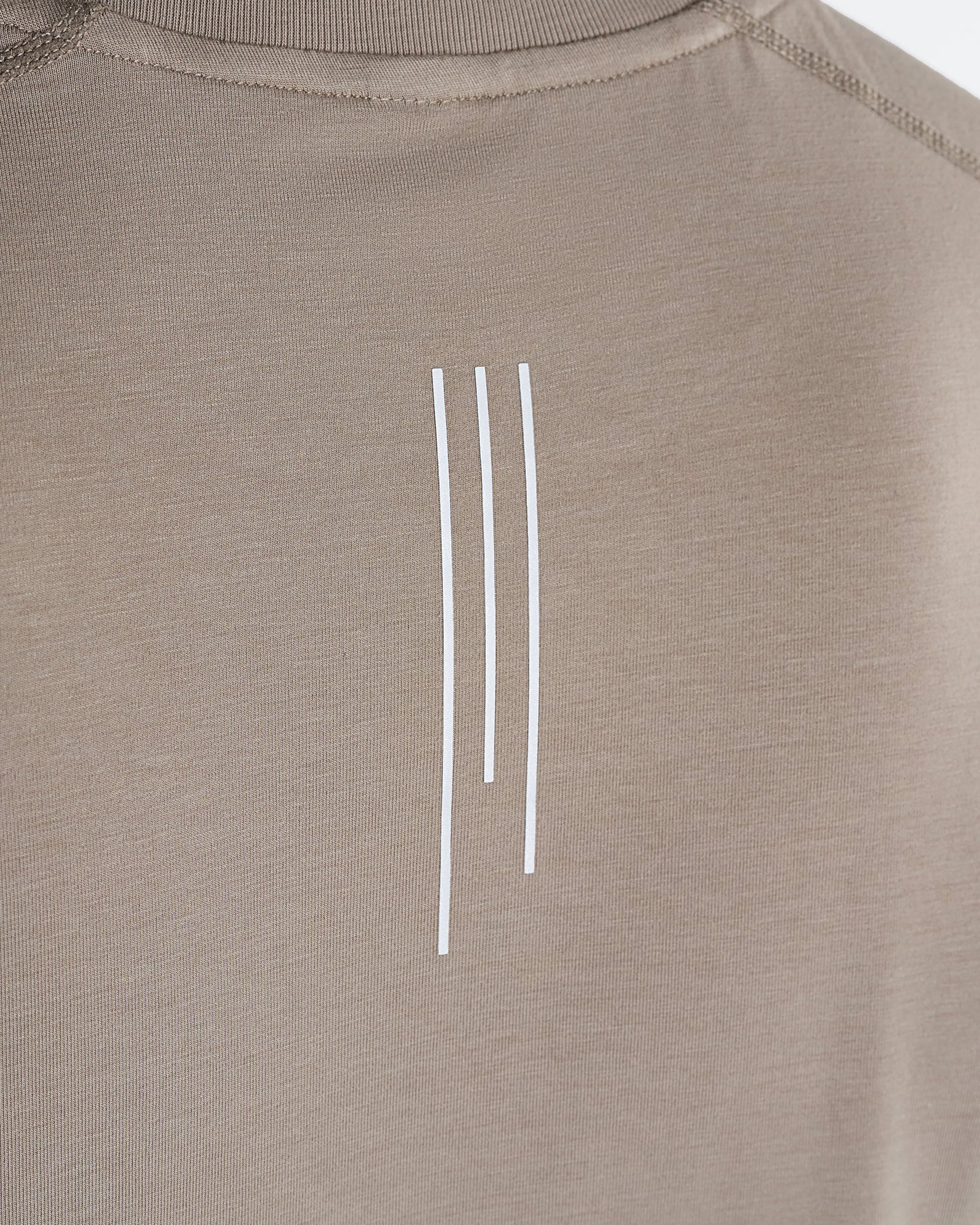 Close-up of the Core Raglan Cutoff in Sand showing three white vertical lines printed on the chest.