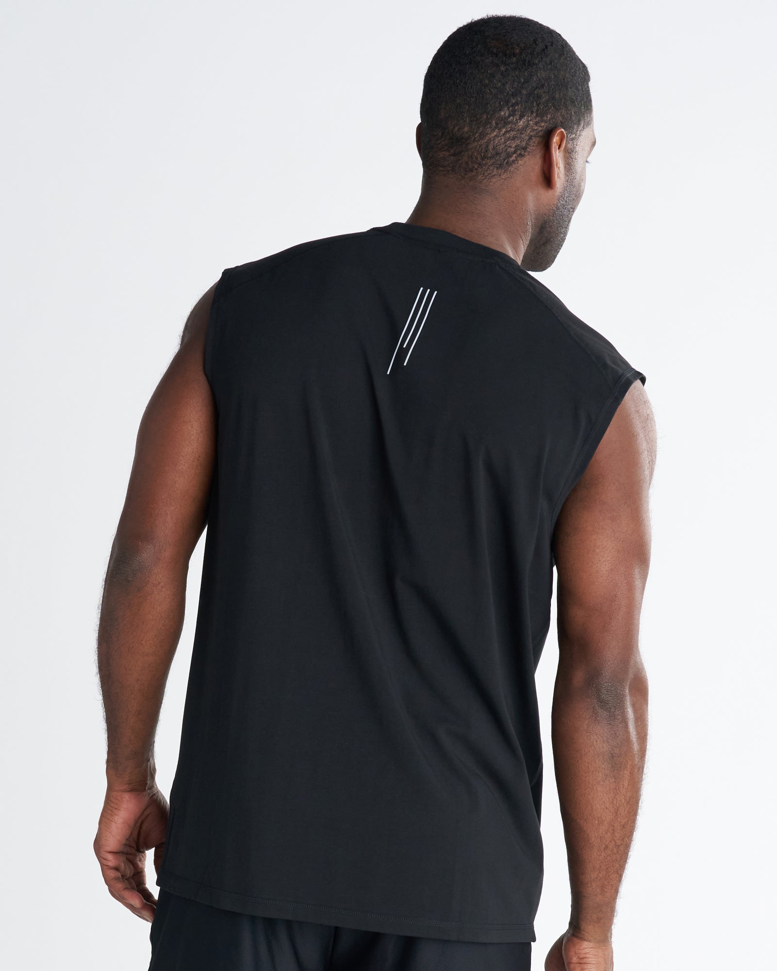 Back view of a man wearing the Core Raglan Cutoff in black, showing three-stripe logo detail at upper back.