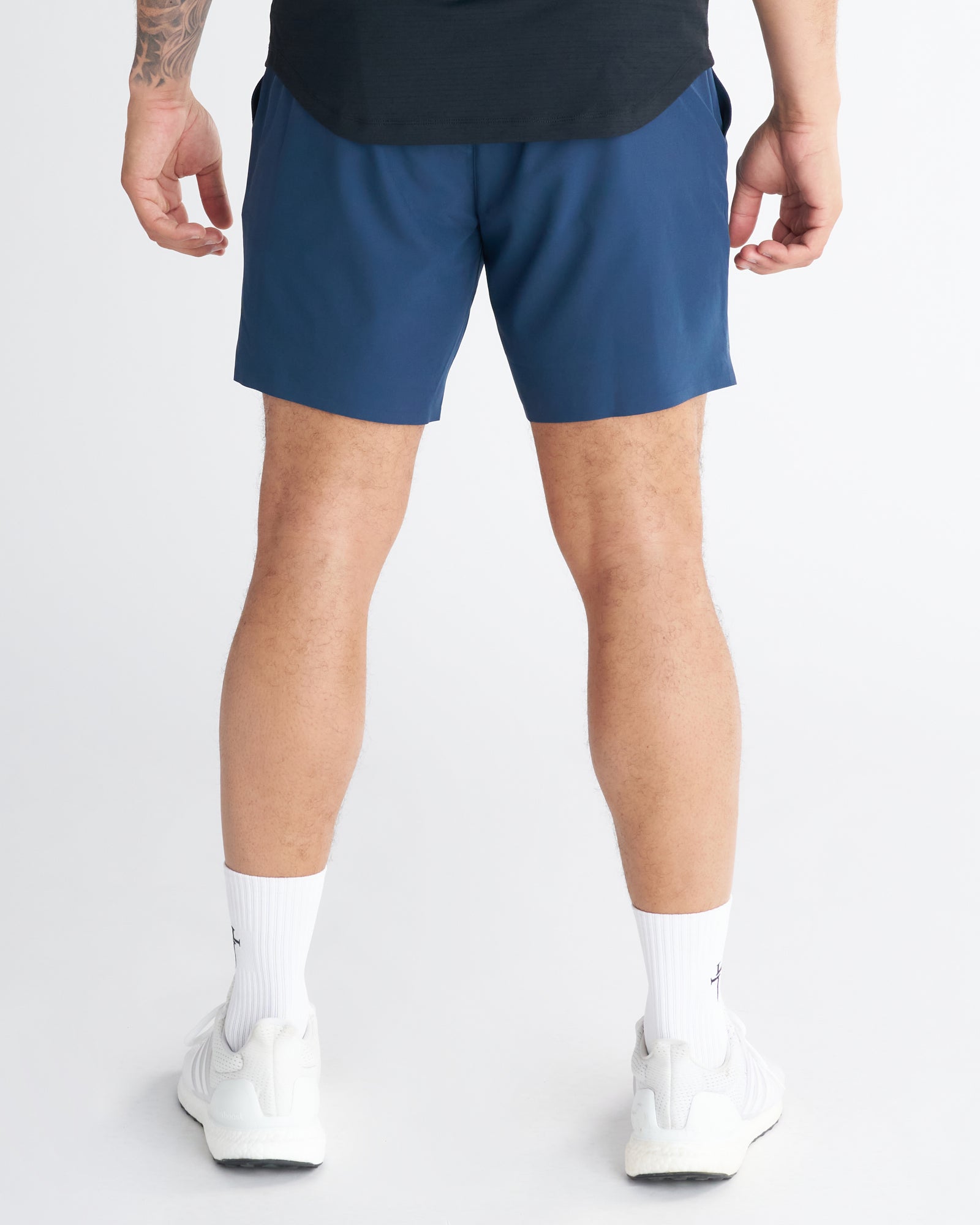 Back view of the Pulse Tech Liner Short in Midnight Navy, worn with white sneakers and socks.