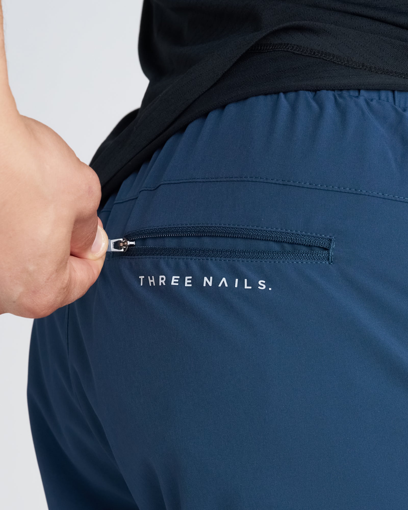 Close-up of the back zip pocket detail on the Pulse Tech Liner Short in Midnight Navy.