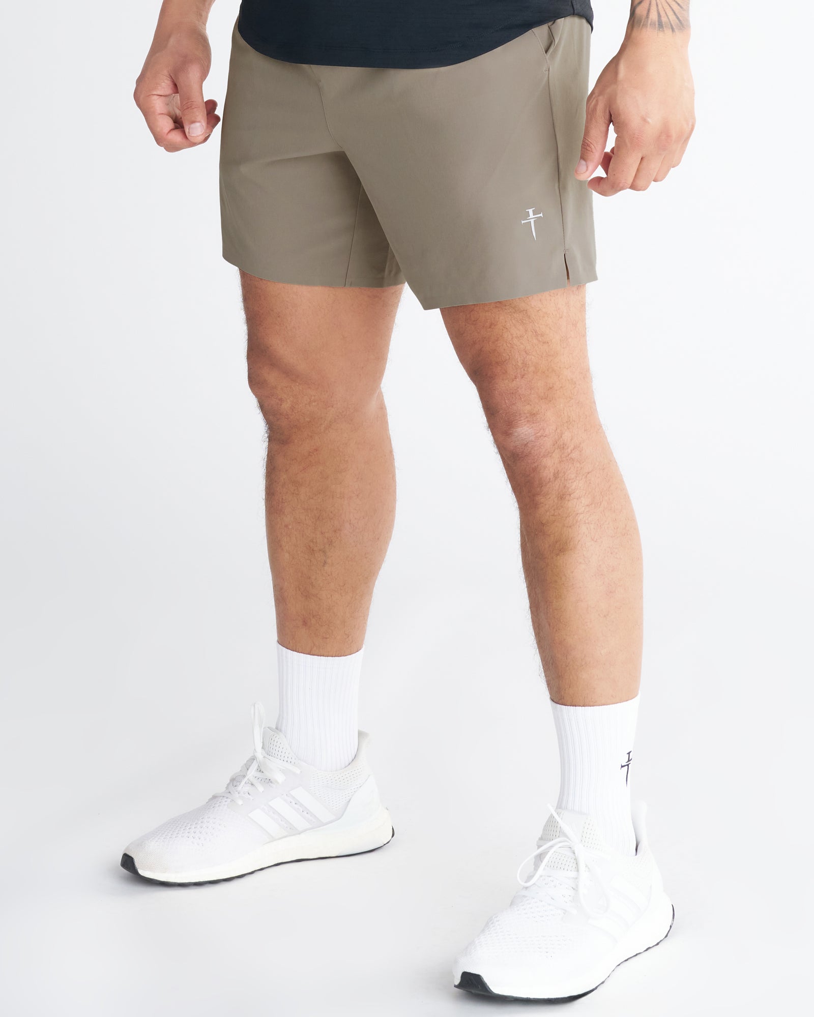 Man wearing Sand Pulse Tech Liner Shorts, side angle view, paired with white Adidas sneakers and white socks.