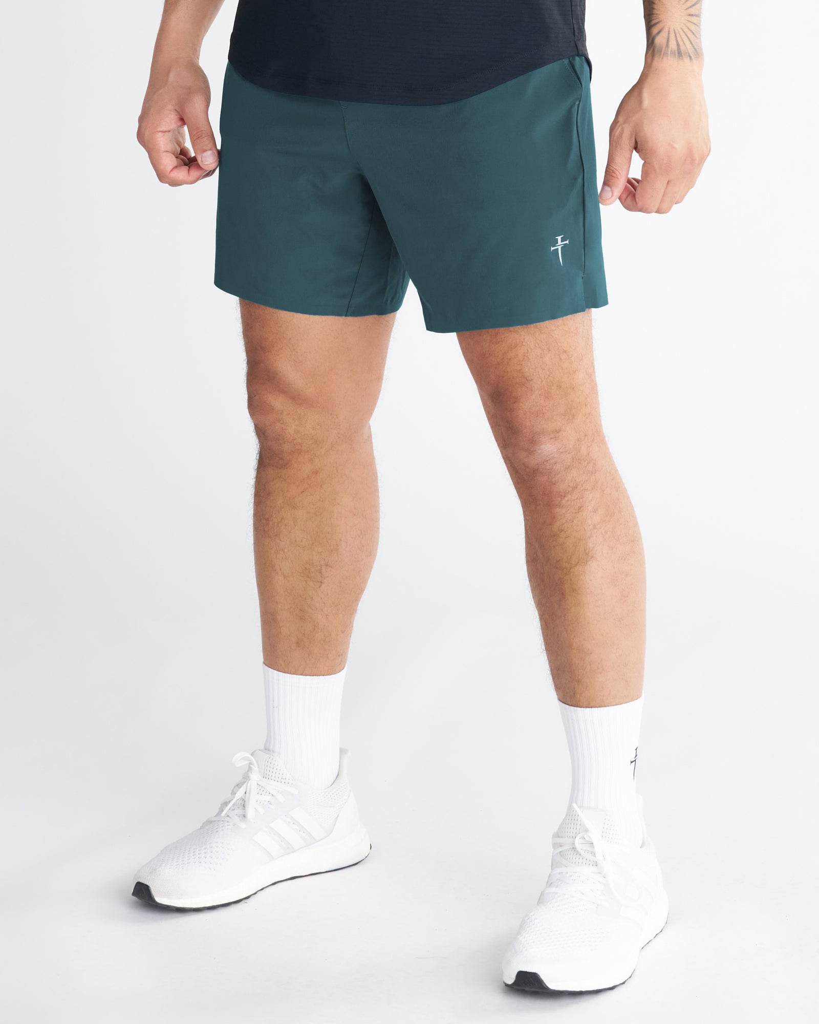Pulse Tech Liner Short in Teal worn by a male model, front side angle view, paired with white Adidas sneakers.