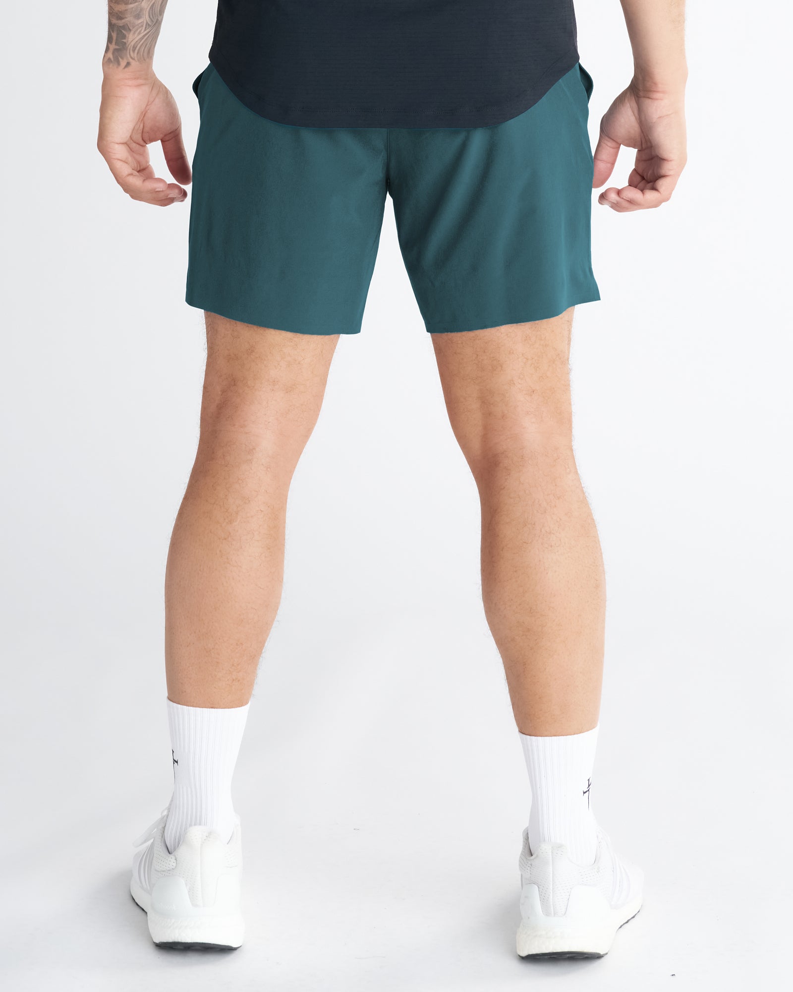 Back view of the Pulse Tech Liner Short in Teal worn by a male model with white sneakers and socks.