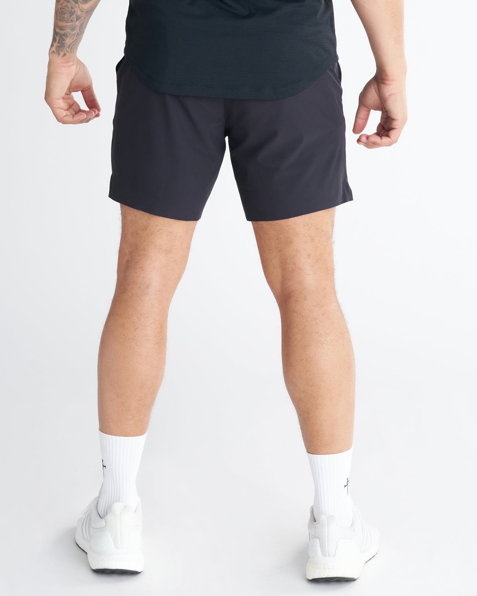 Back view of model wearing the Pulse Tech Liner Short in Black, styled with white sneakers and socks.