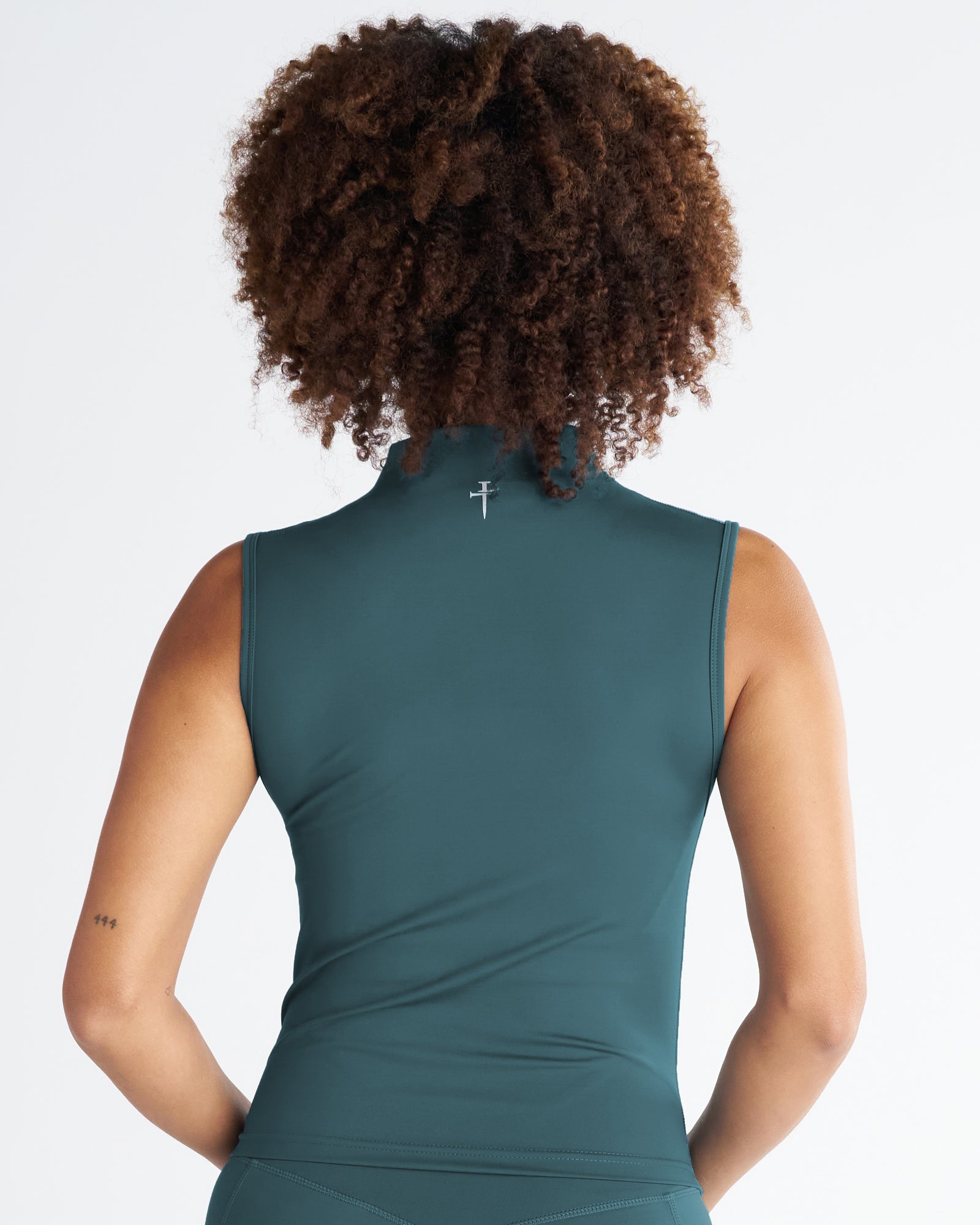 Back view of the Endura-Train Quarter Zip Tank in Teal on a model with curly hair, showing the mock neck and sleeveless fit.