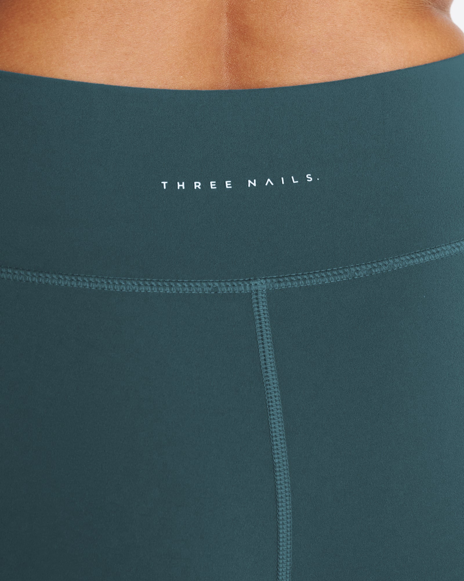 Close-up of the Nova Pocket Legging 27" in Teal showing the waistband, Three Nails logo, and front seam detail.