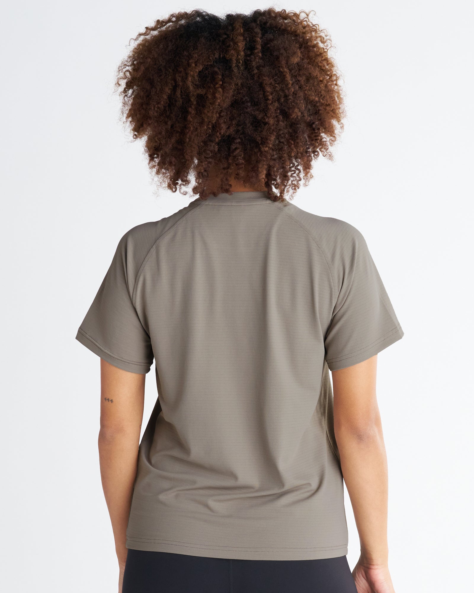 Back view of the Women's Aion-Lite Tee Cross in Sand, showing raglan sleeves and clean seam details.