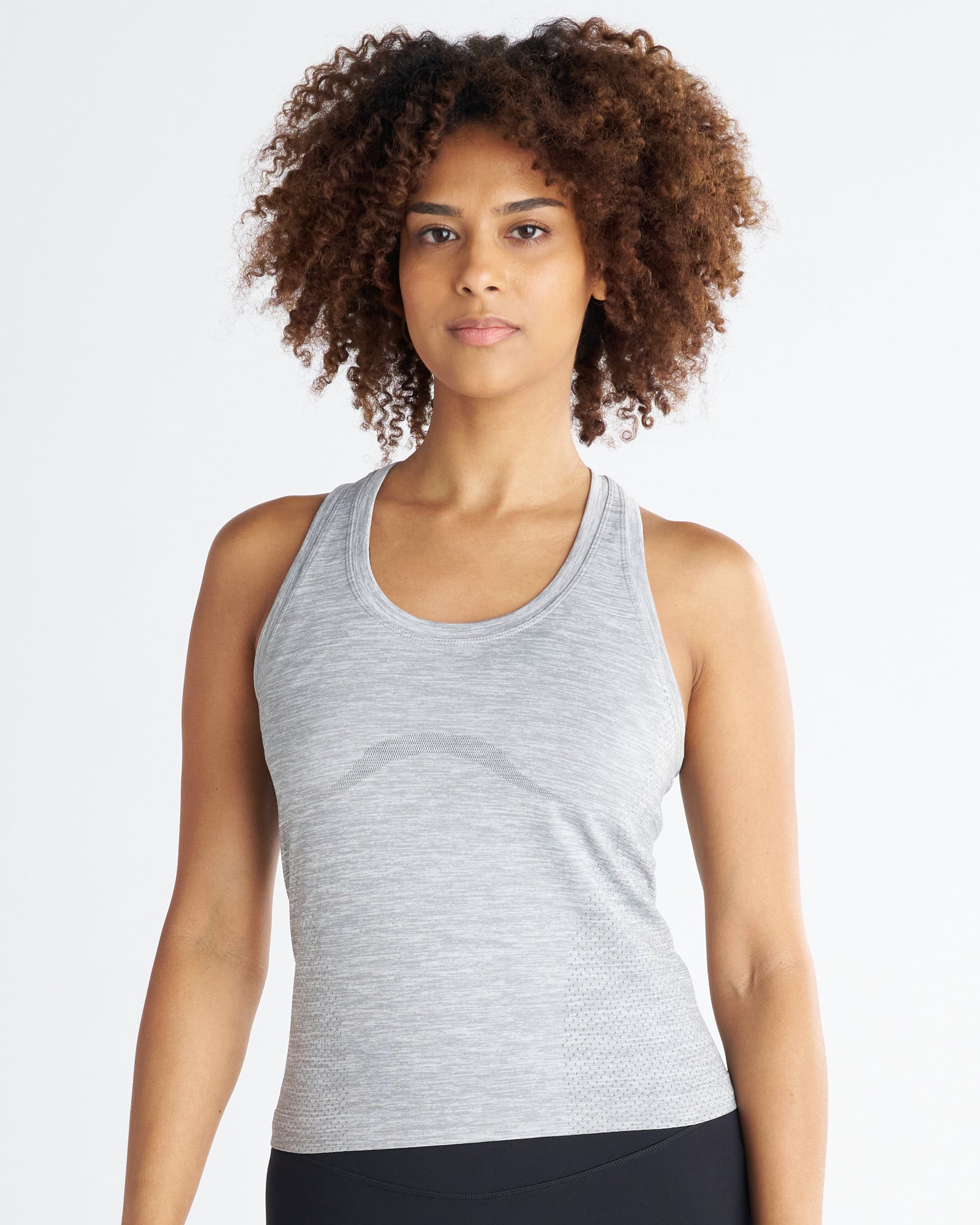 Women's Seamless Tank in Grey Marl, front view on model with curly hair, fitted racerback silhouette.
