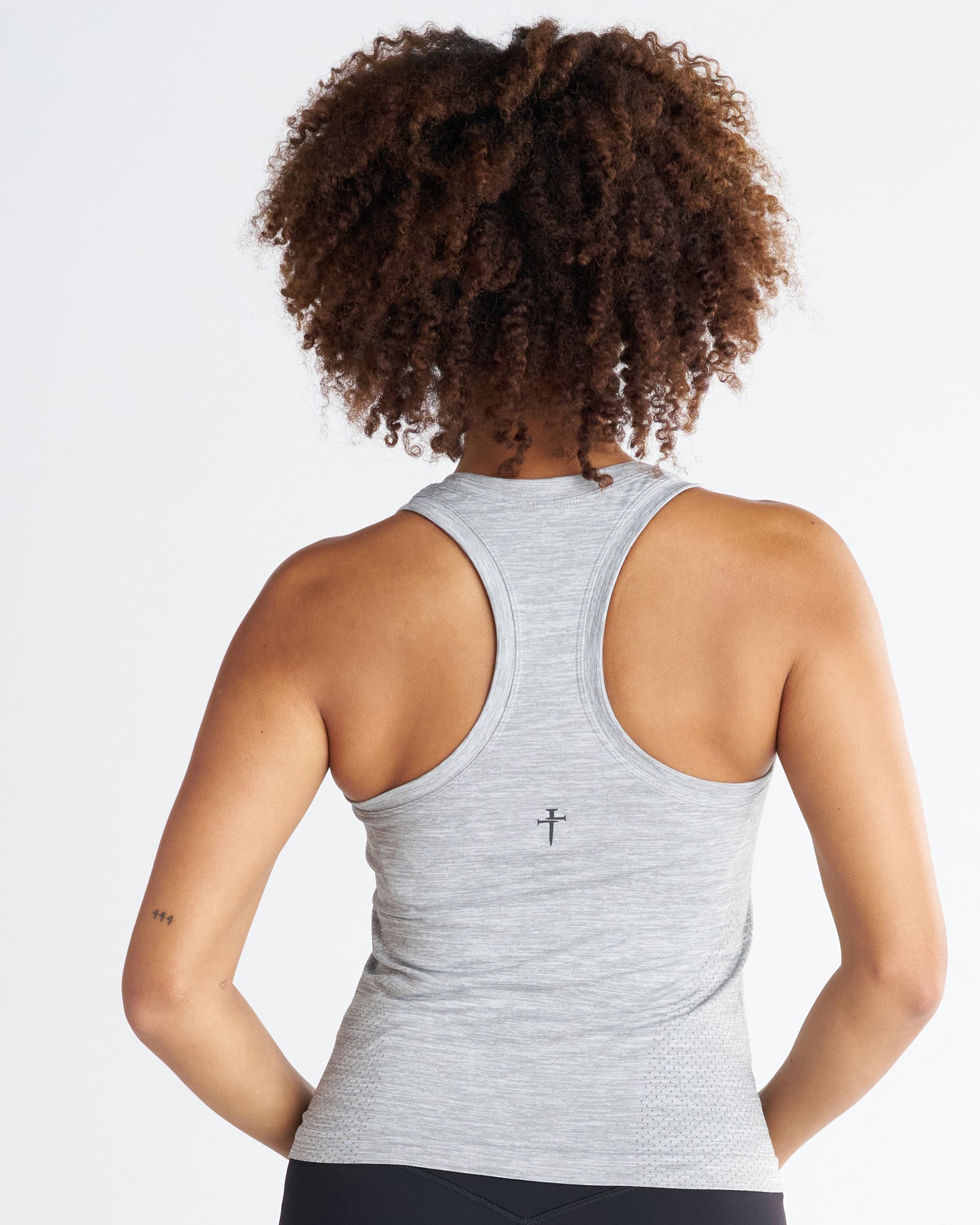 Women's Seamless Tank in Grey Marl, back view on model showing racerback design and small cross logo.