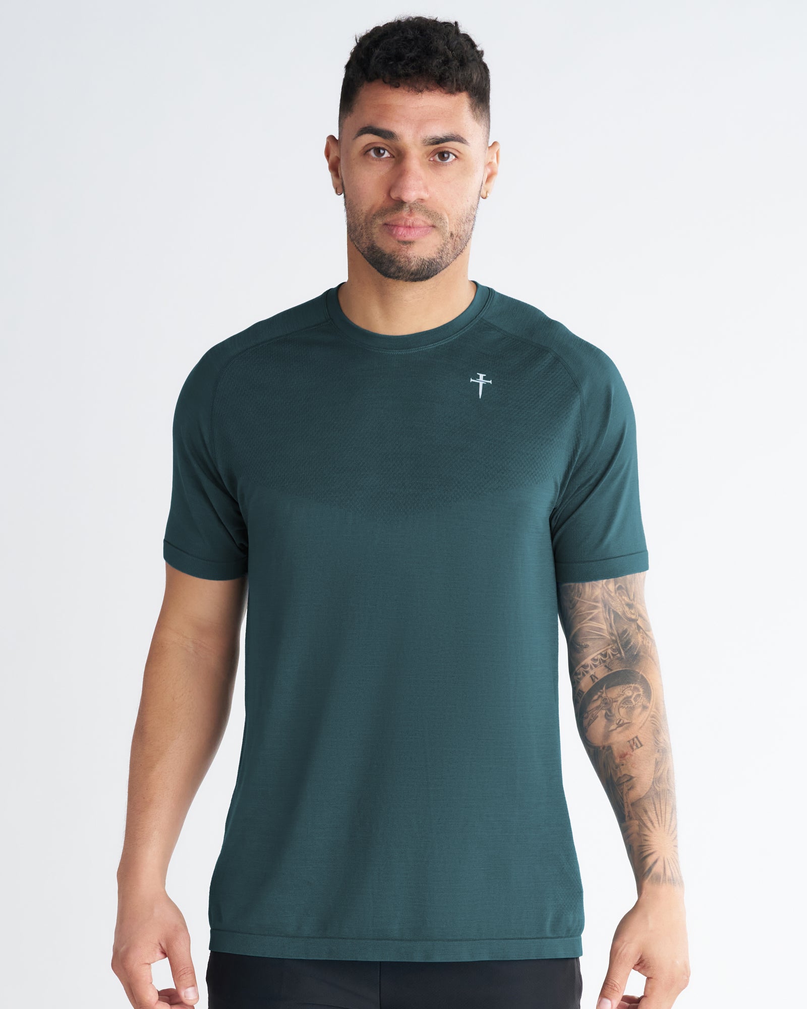 Man wearing the Seamless Tee in Teal, front view, with a small logo on the chest.