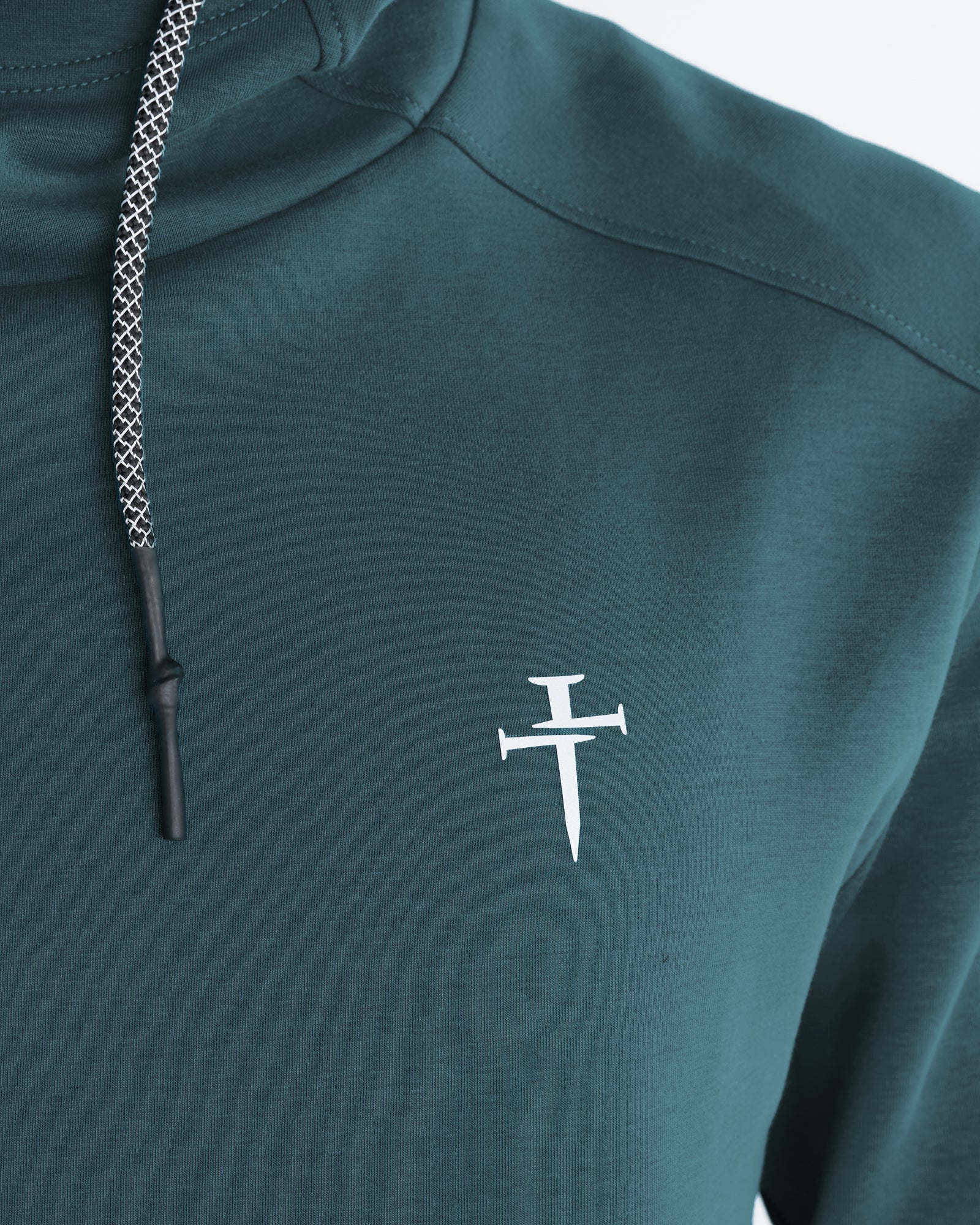 Close-up of the Pro-Tech Hoodie in Teal showing the white nail cross logo on the chest.